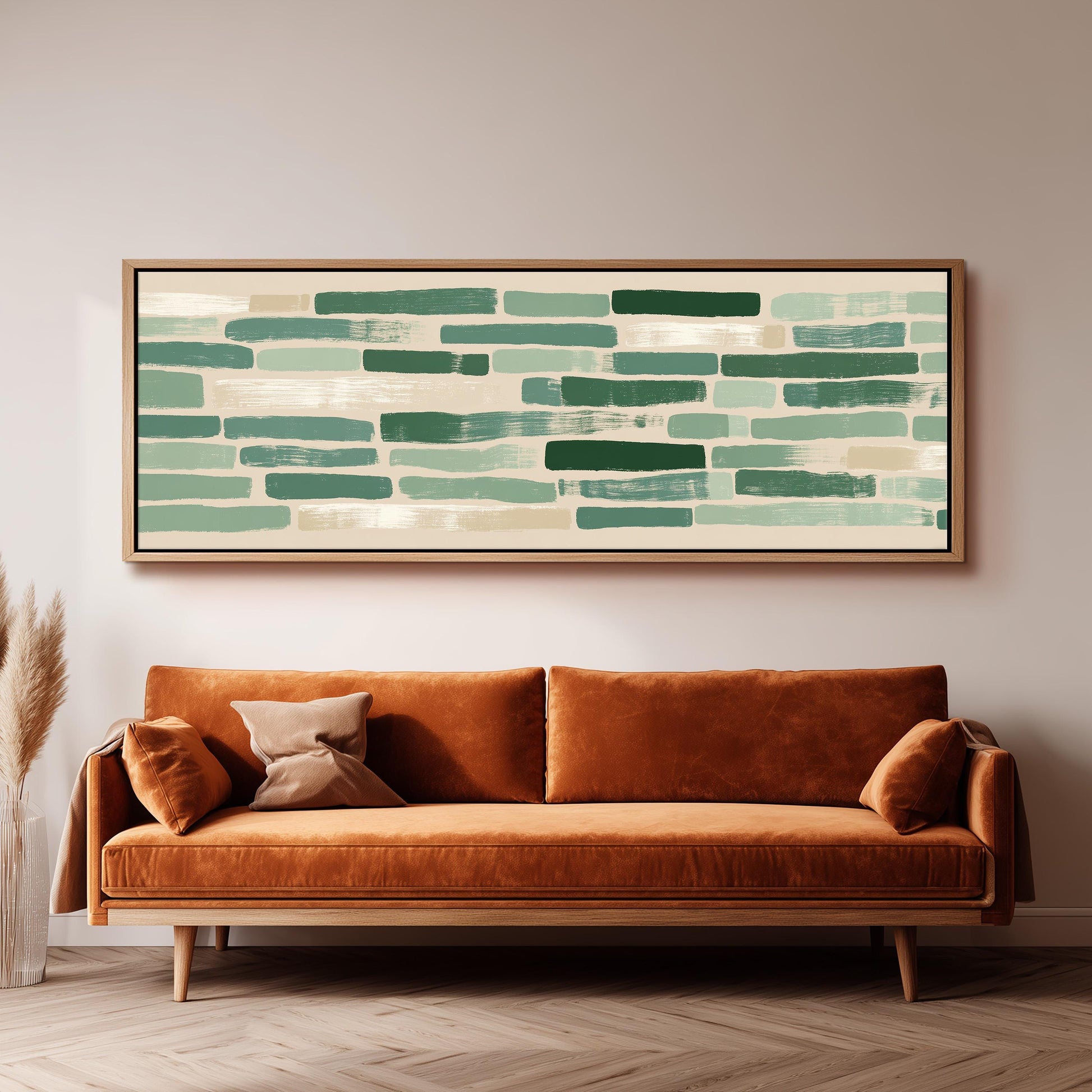 a large, rectangular painting hanging on a wall above a brown sofa with orange cushions.