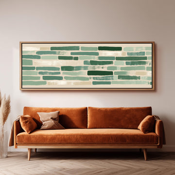 a large, rectangular painting hanging on a wall above a brown sofa with orange cushions.