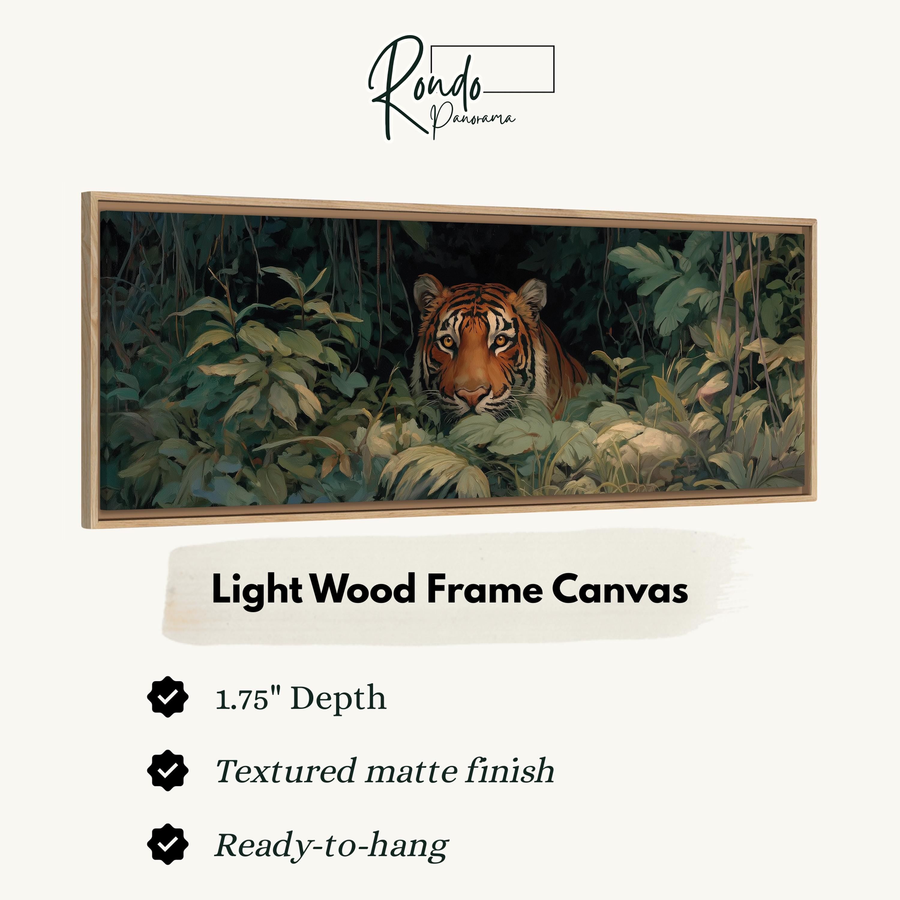 A framed painting of a tiger peeking out from the foliage in a lush, green jungle setting.