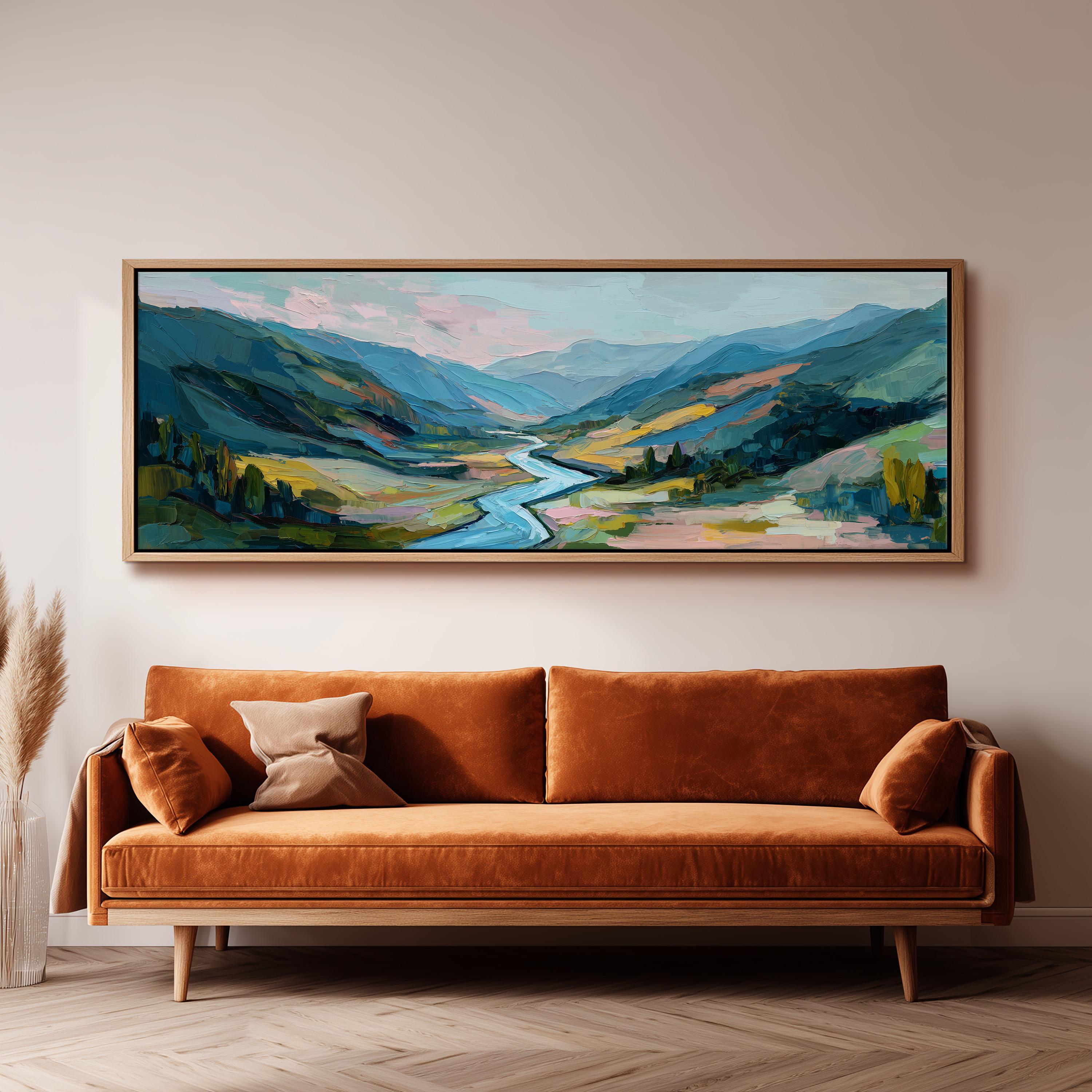 a large landscape painting hanging on a wall above a brown sofa with orange cushions.