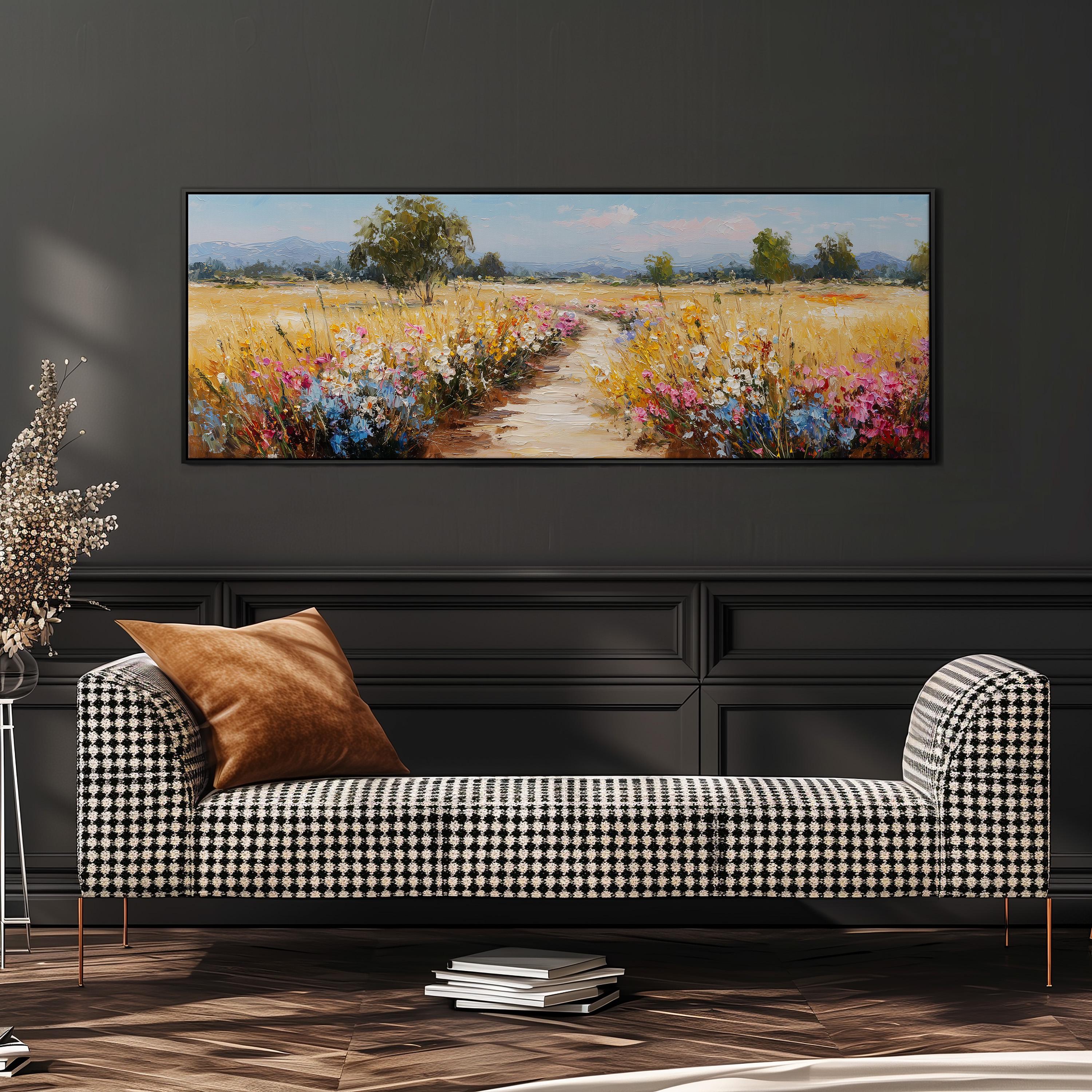 a large painting of a field with flowers hanging on a wall above a black and white checkered sofa.