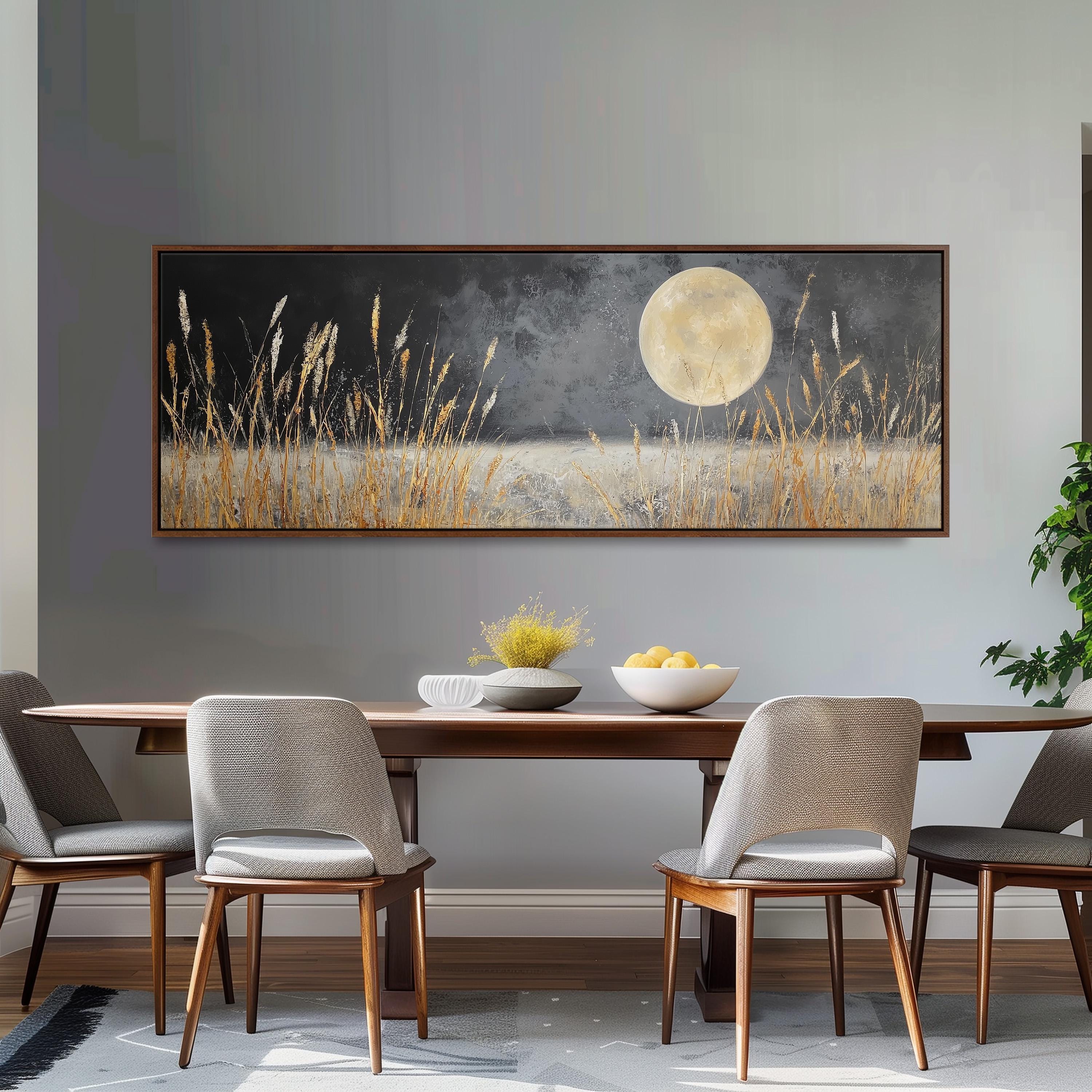 a dining room with a large painting of a field of tall grass and a full moon hanging on the wall above a wooden dining table with four chairs.