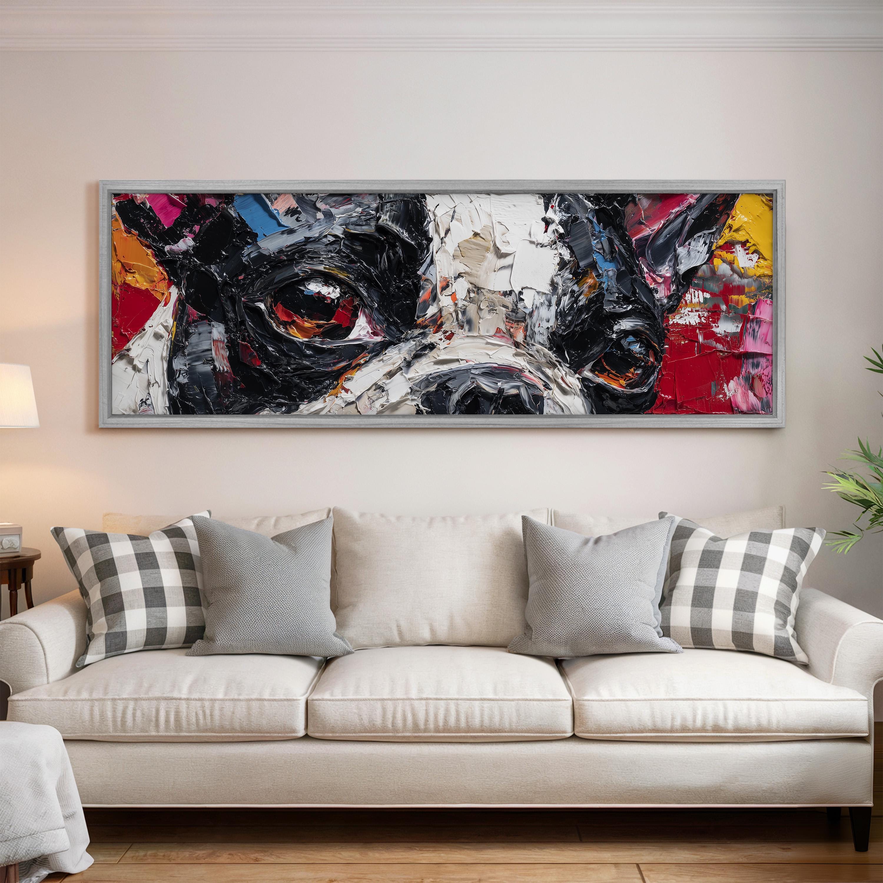 a large, colorful painting of a dog's face hanging on a wall above a white couch in a living room.