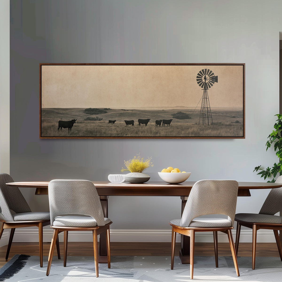 Black cattle grazing by a windmill on the prairie long horizontal canvas print above a dining table