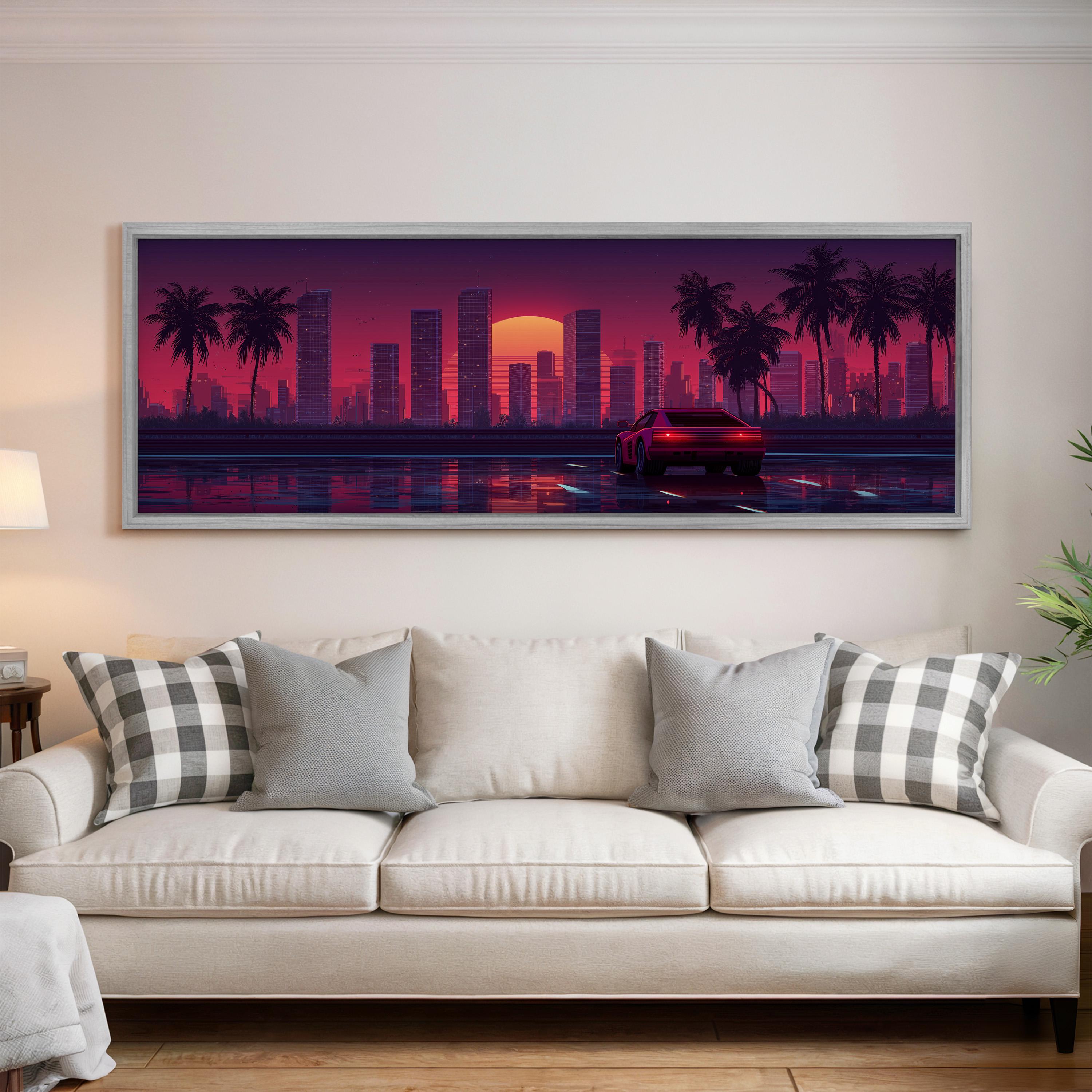 a large, framed artwork depicting a cityscape at sunset, with palm trees and a car driving on the road.