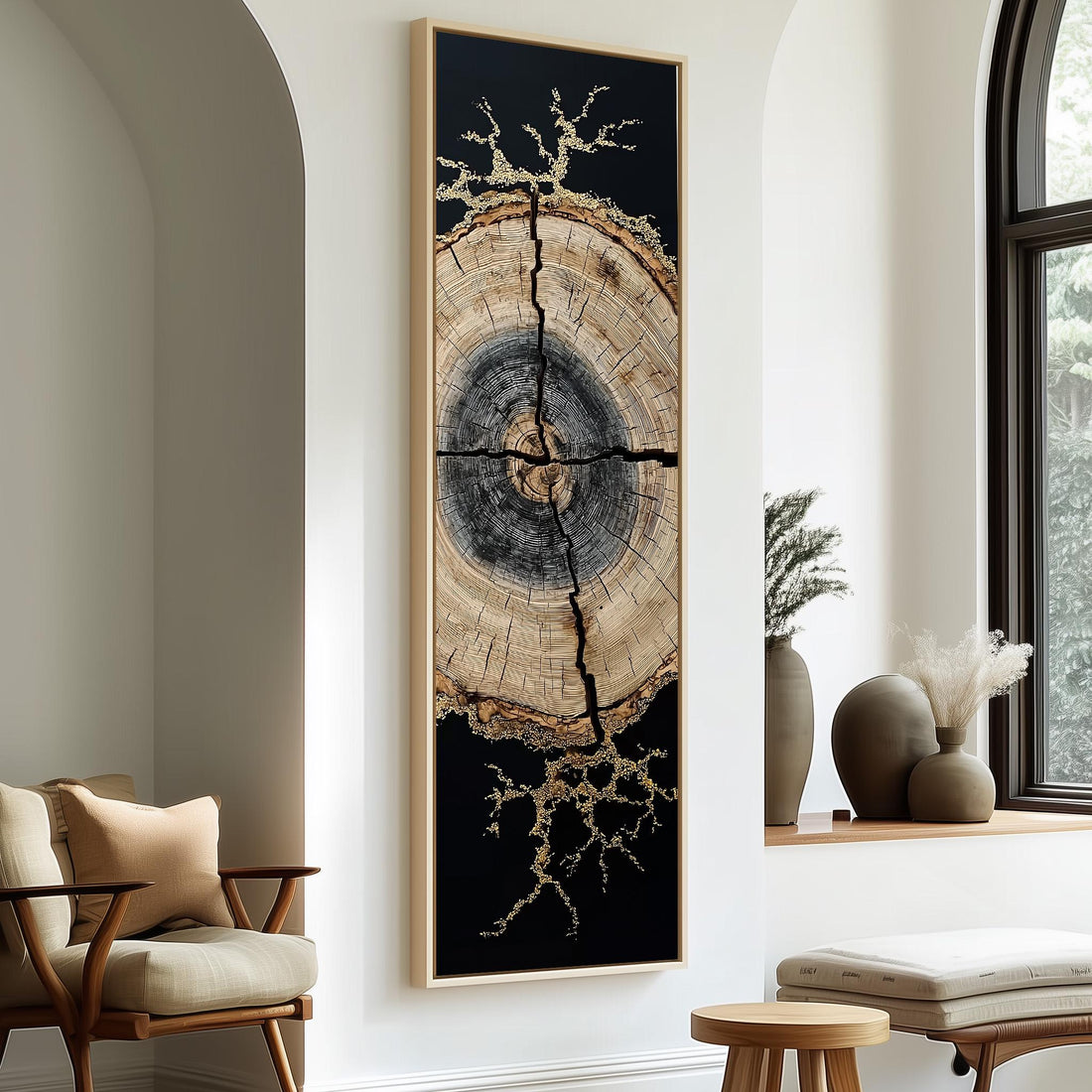 a large, abstract painting of a tree trunk with a black background and gold accents, hanging on a white wall. The painting is framed in black and is positioned between two chairs, one on each side. The room also includes a window, a small table, and some decorative elements such as vases and a potted plant.