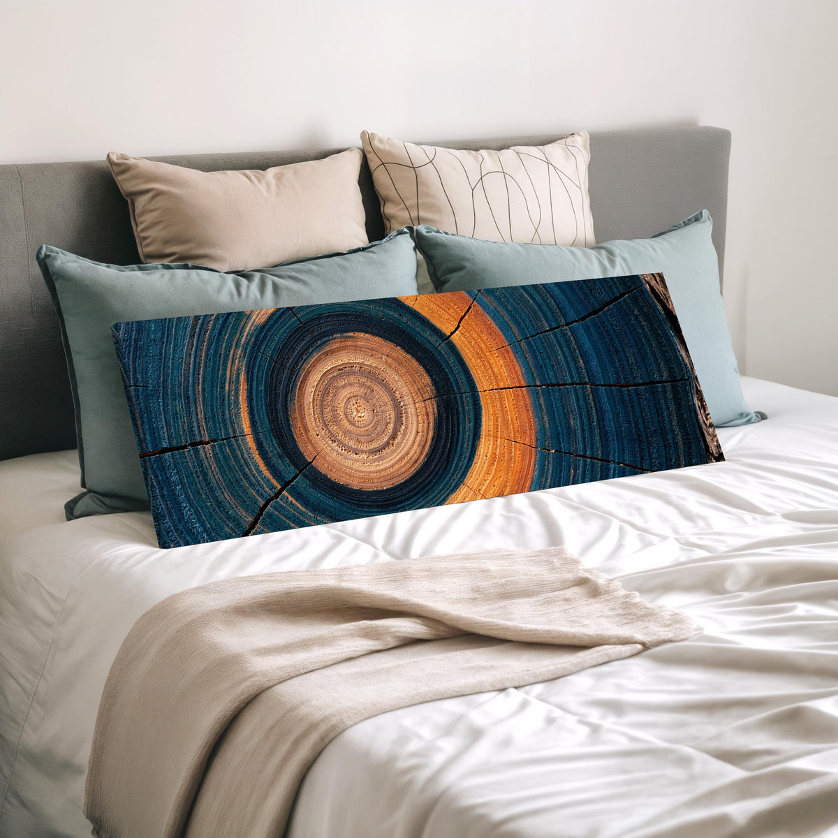 Teal and orange tree ring wide panoramic canvas print laid on a bed to show its size
