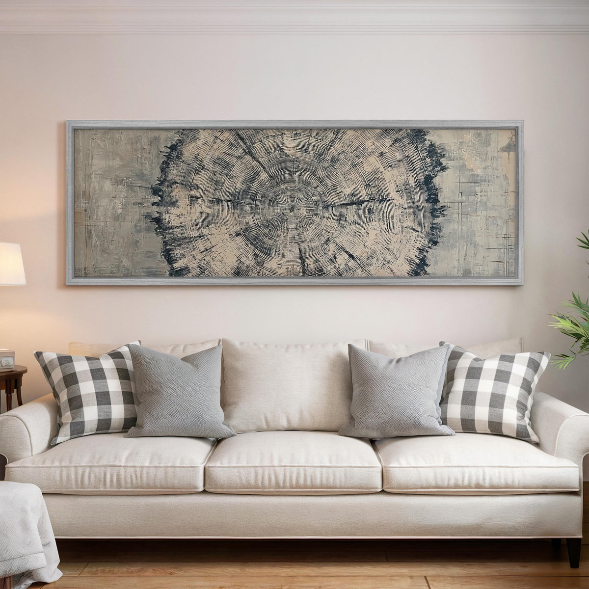 Navy ink tree ring panoramic canvas print above a white sofa in a bright living room