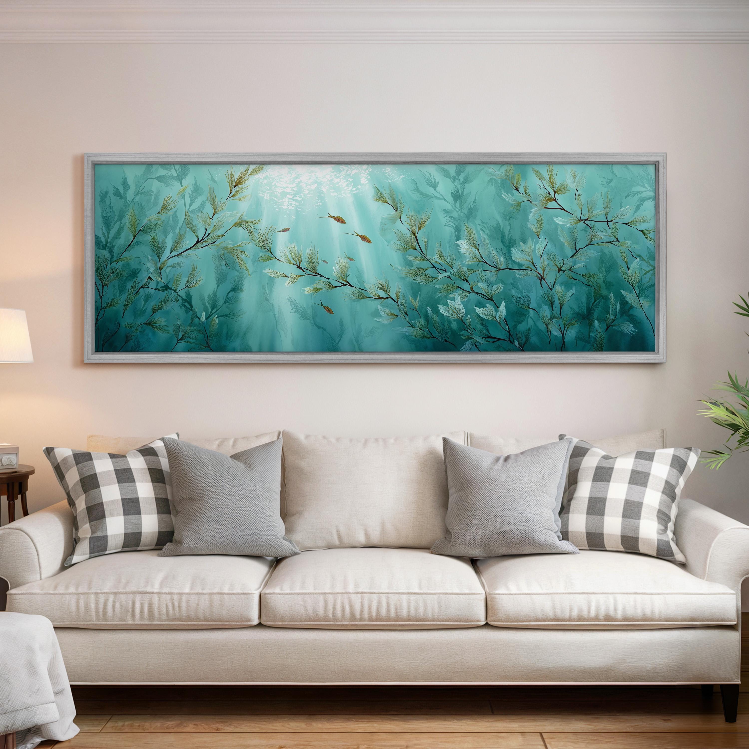 a large, framed painting of a serene underwater scene hanging on a wall above a white couch with gray and white patterned pillows.