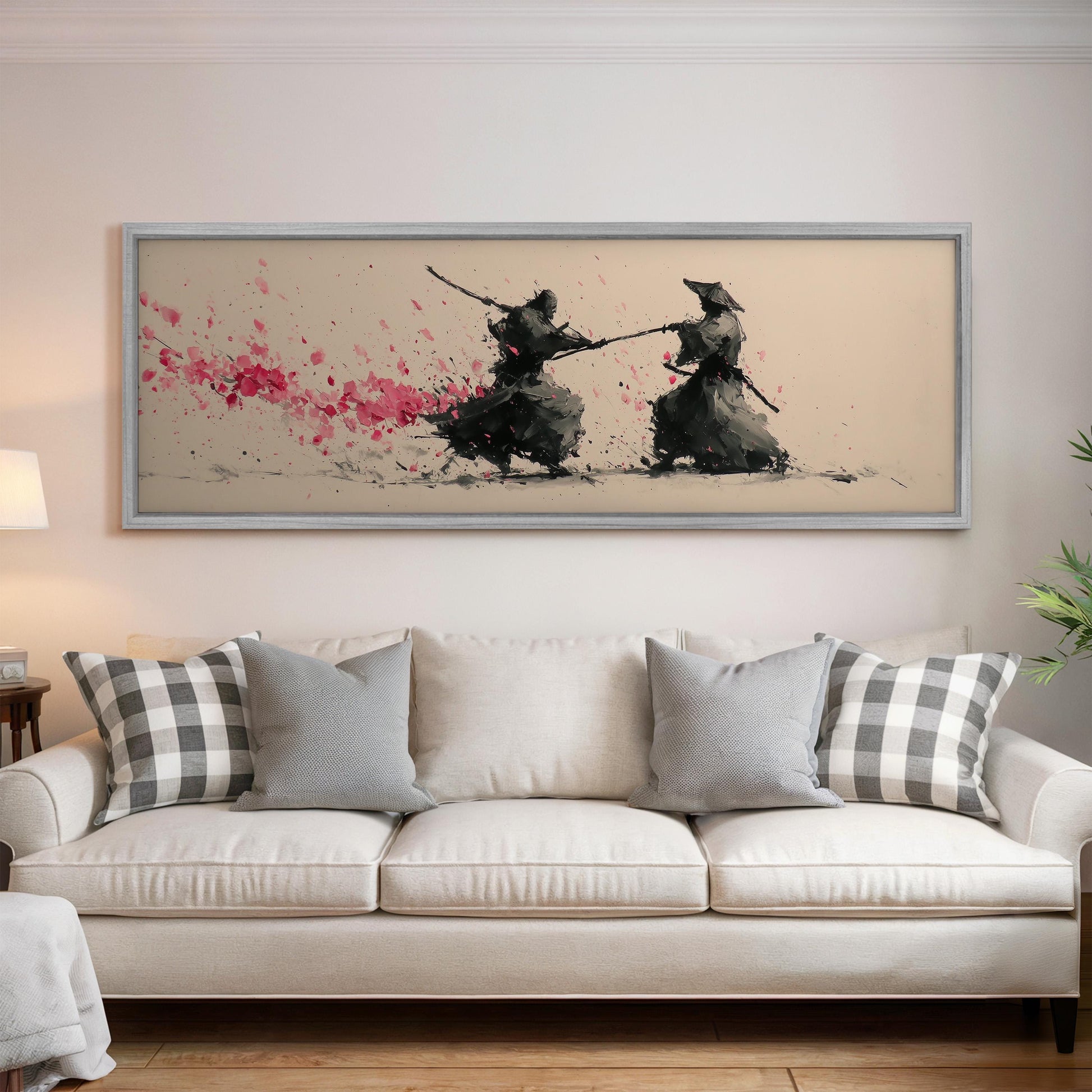 a living room with a white sofa and a framed artwork depicting two figures engaged in a sword fight.