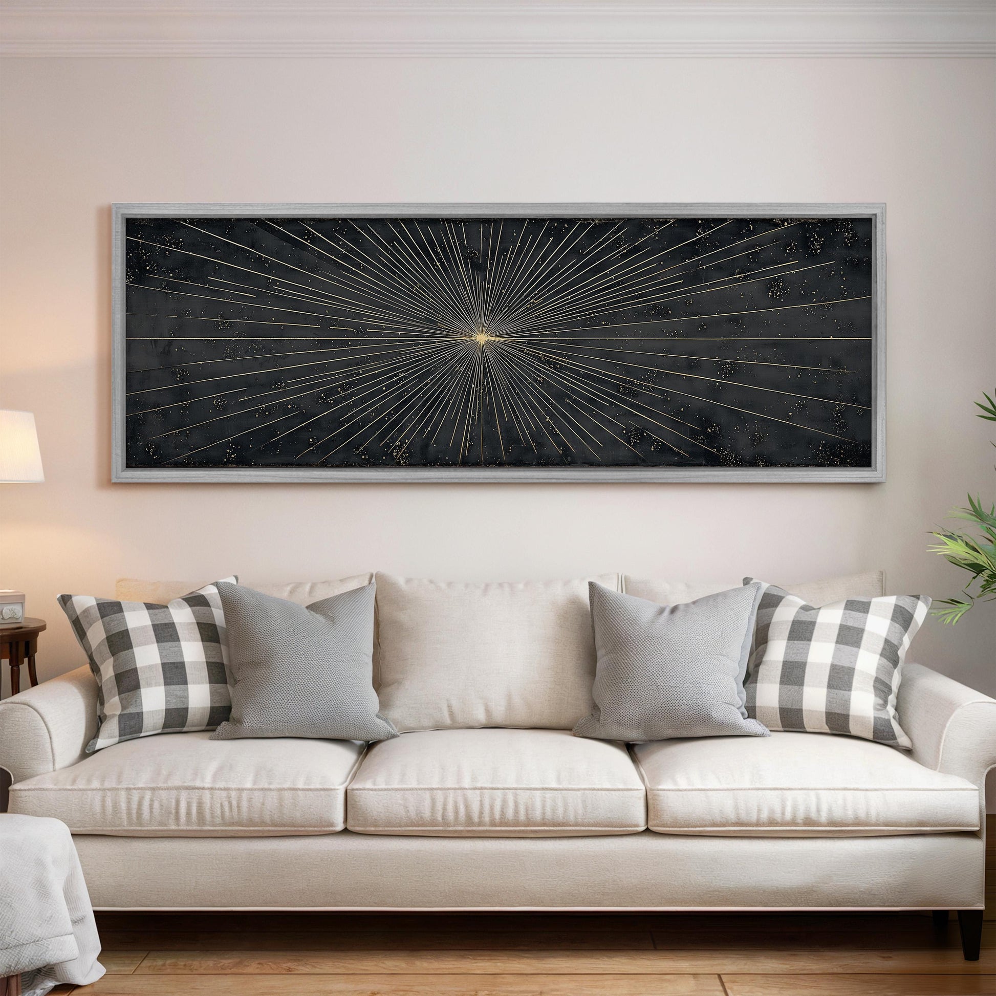 a large black and white abstract painting hanging on a white wall above a white sofa with gray and white patterned throw pillows.