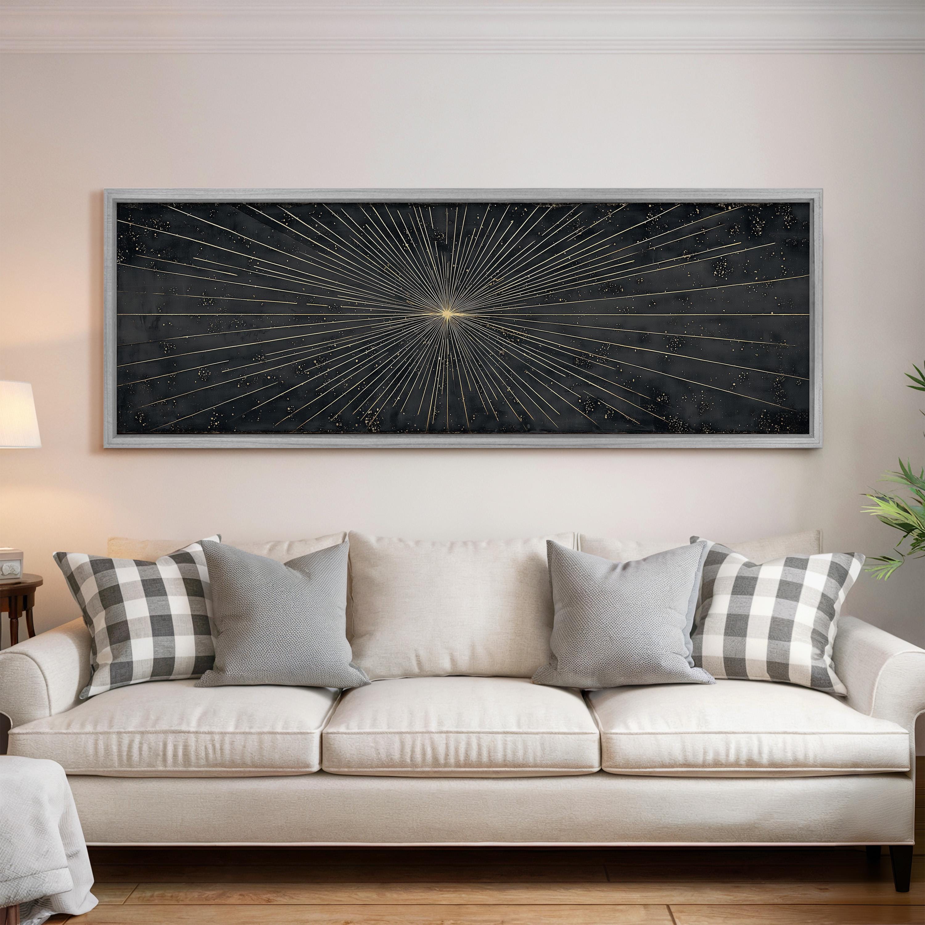 a large black and white abstract painting hanging on a white wall above a white sofa with gray and white patterned throw pillows.