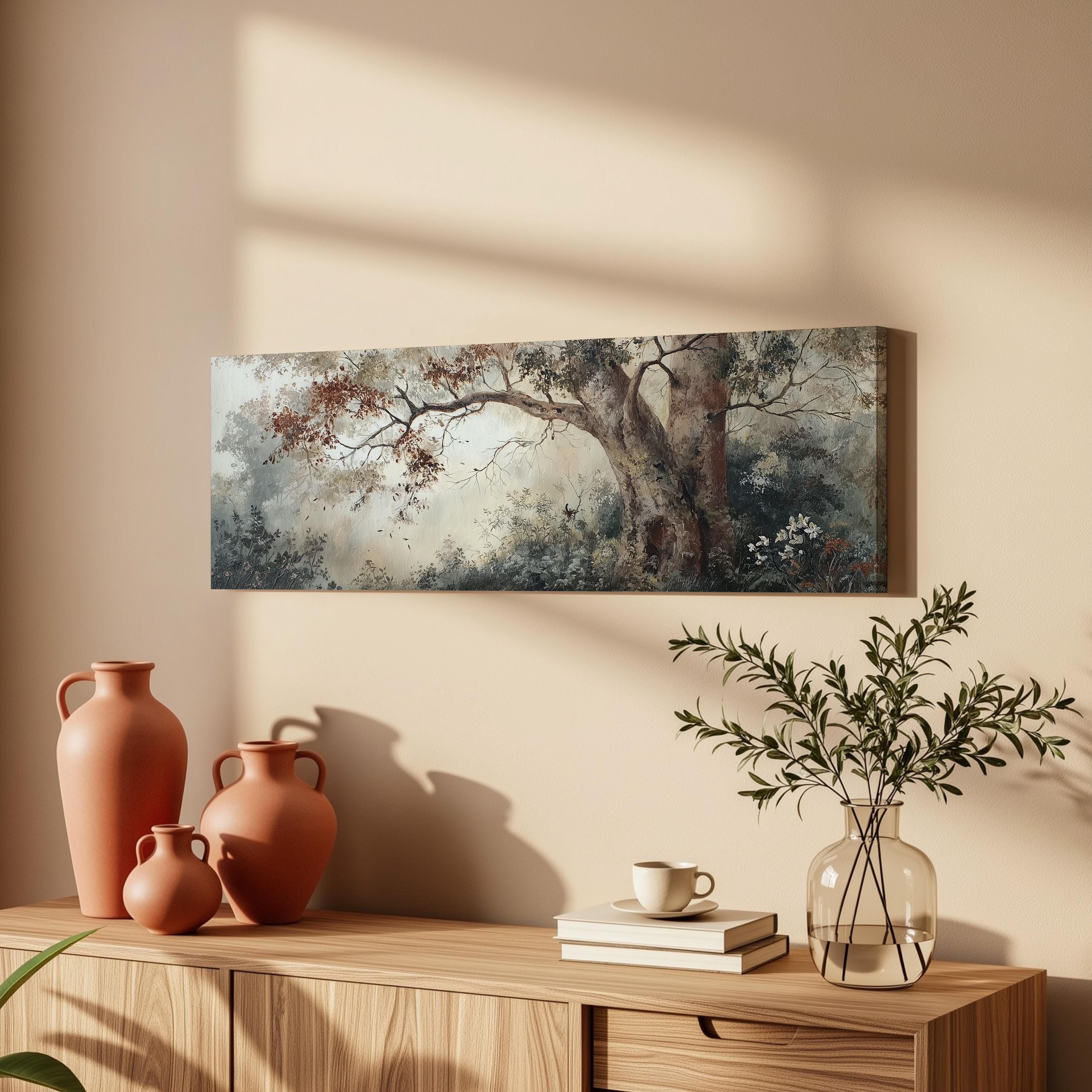 a wooden cabinet with a painting of a tree hanging on the wall above it, along with three orange vases and a glass vase with greenery.