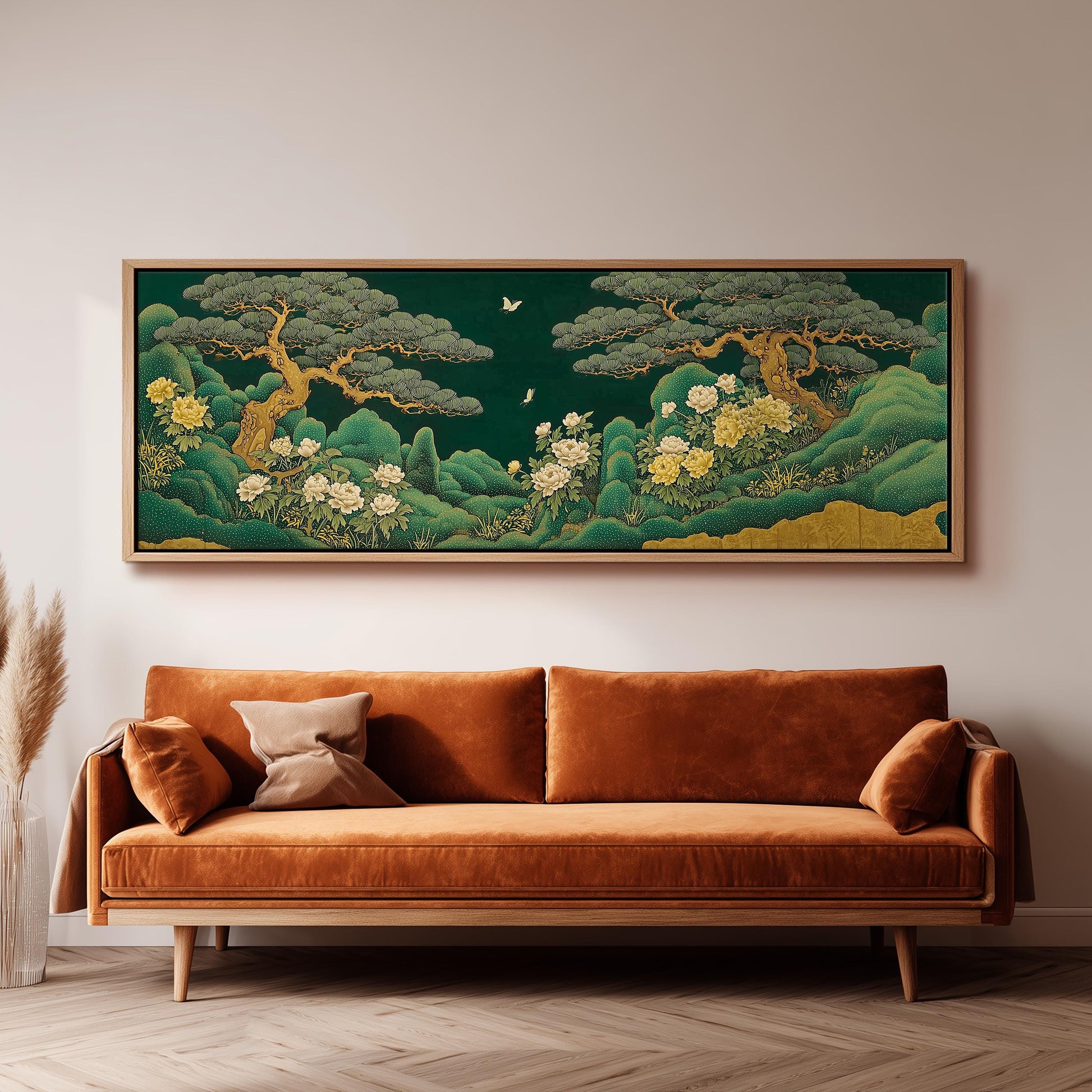 a large, framed painting of a lush, green landscape with trees, flowers, and a bird in flight, hanging on a wall above a brown sofa.