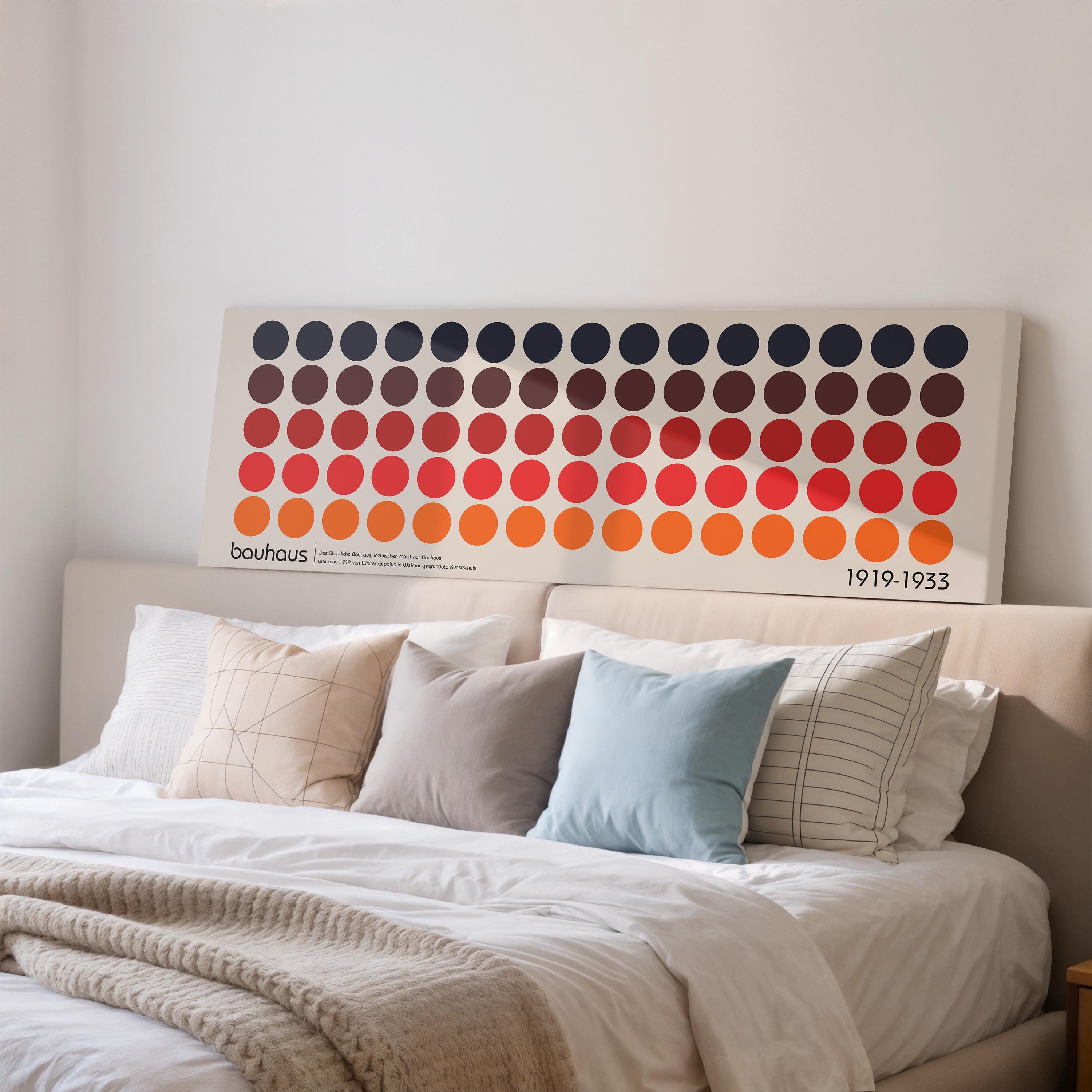 a large, colorful abstract artwork displayed on a wall above a bed with white linens and pillows.