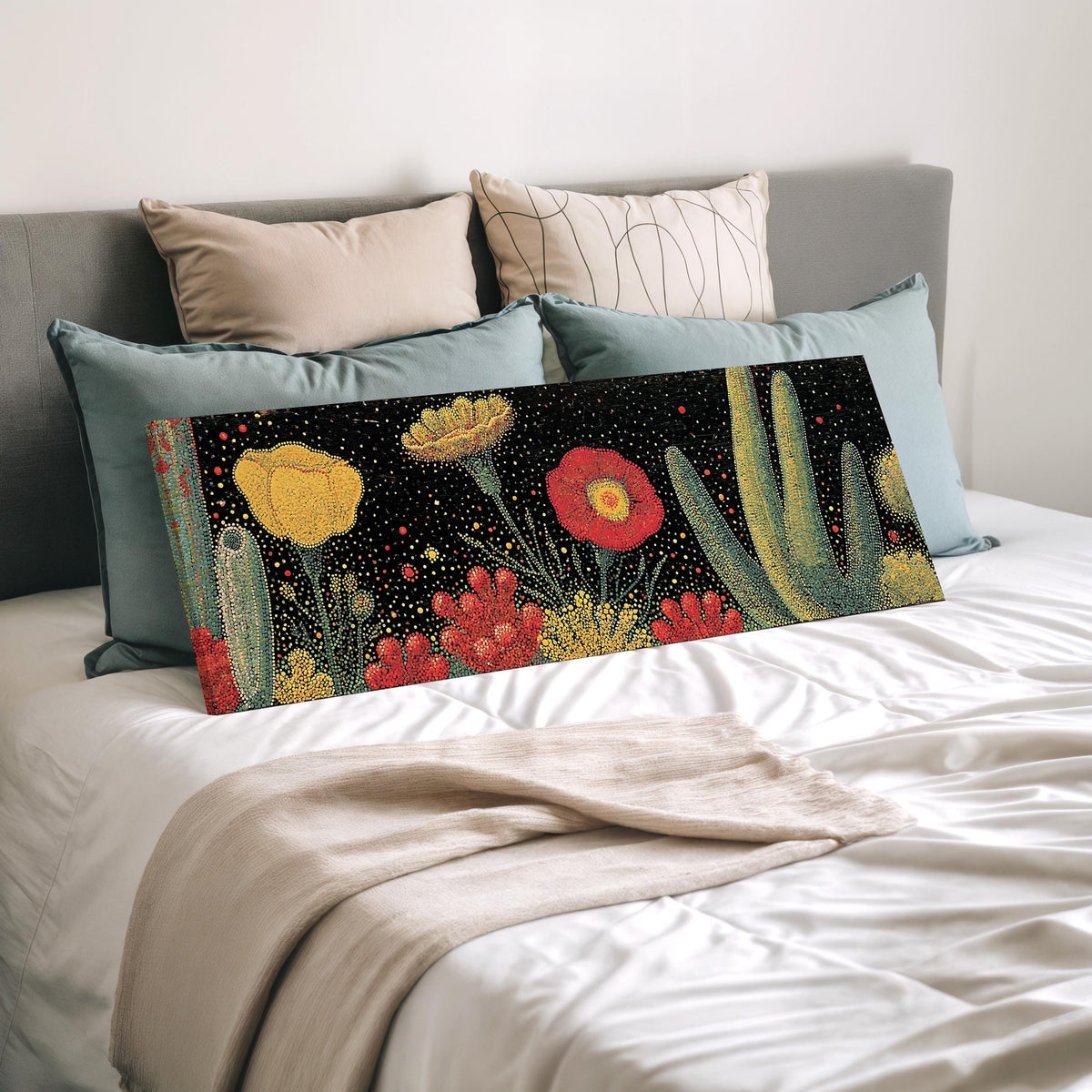 Desert blooms and cacti on black wide panoramic canvas print laid on a bed to show its size