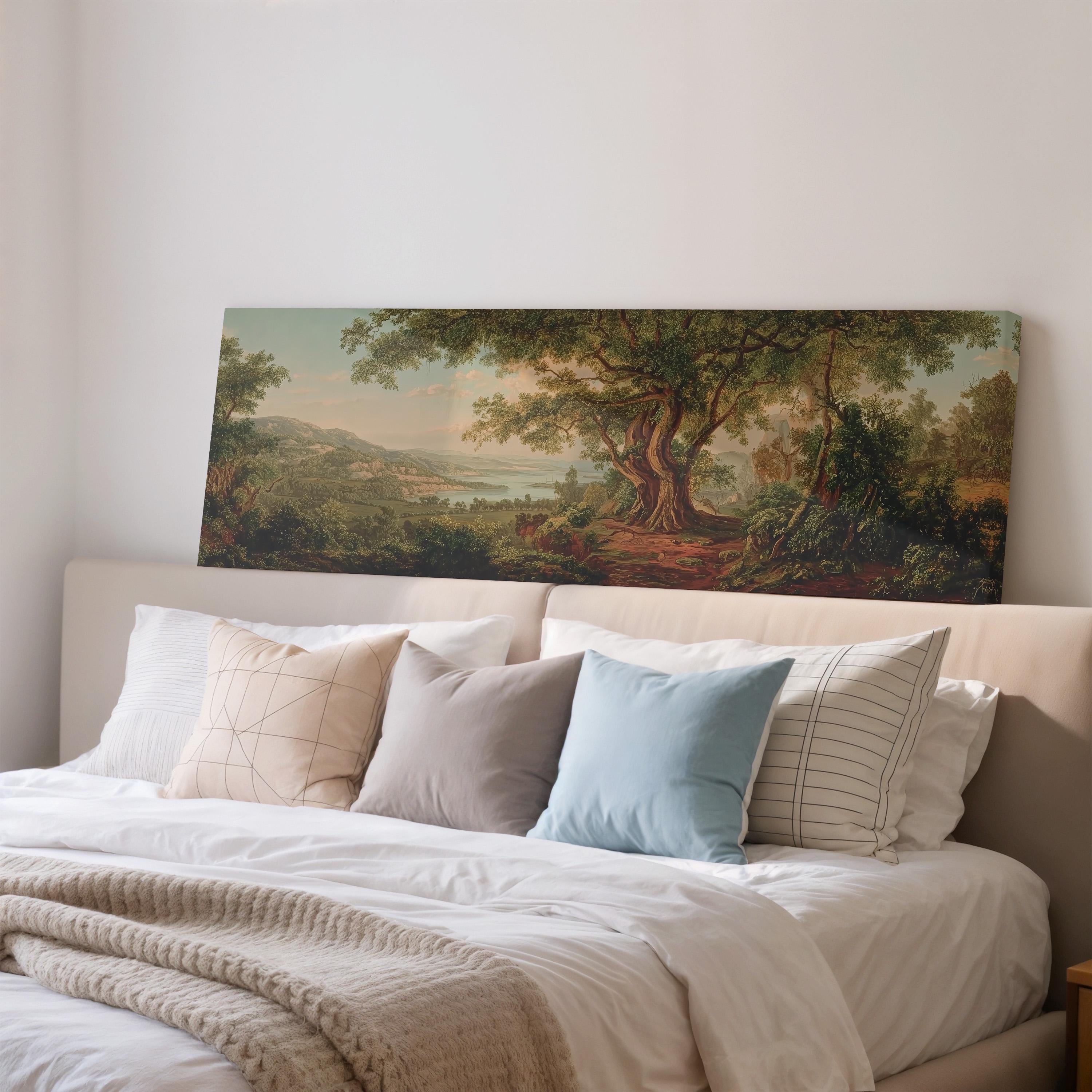 a large painting of a landscape hanging on a wall above a bed with white bedding and pillows.