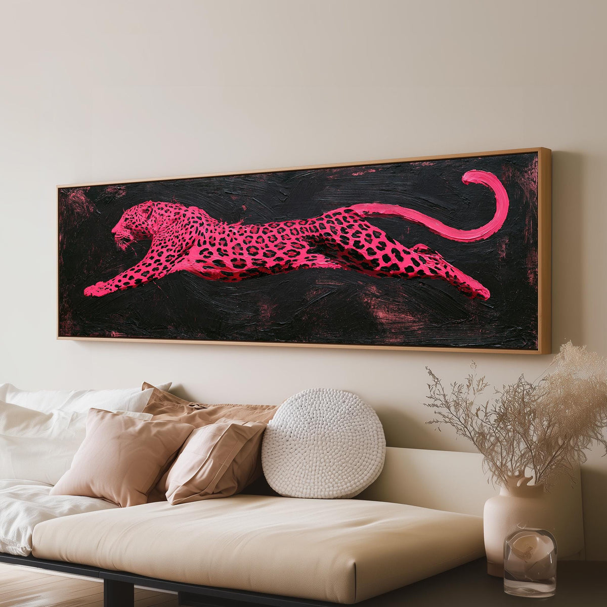 Pink leaping leopard panoramic canvas print above a sofa in a living room