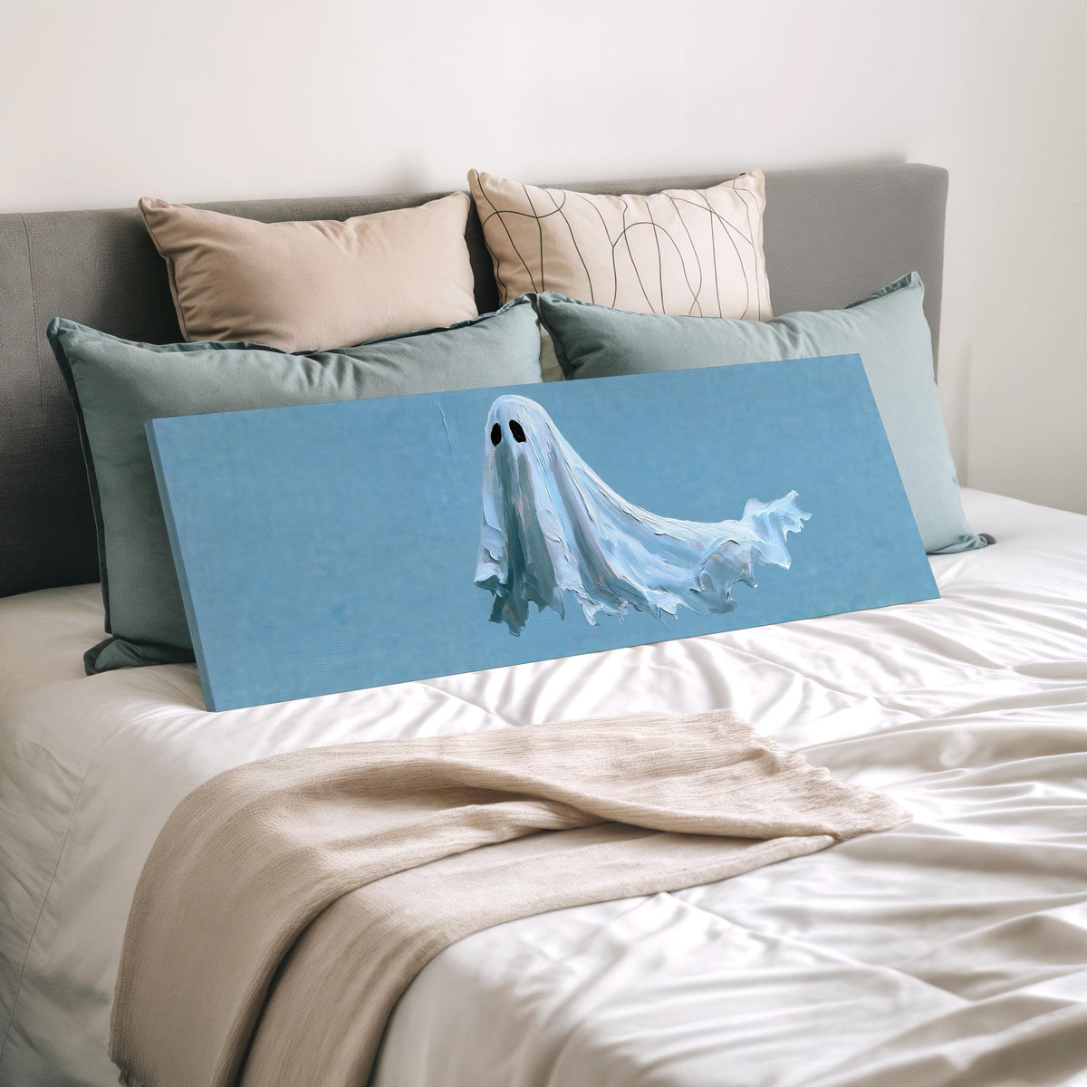 Floating ghost on blue wide panoramic canvas print laid on a bed to show its size