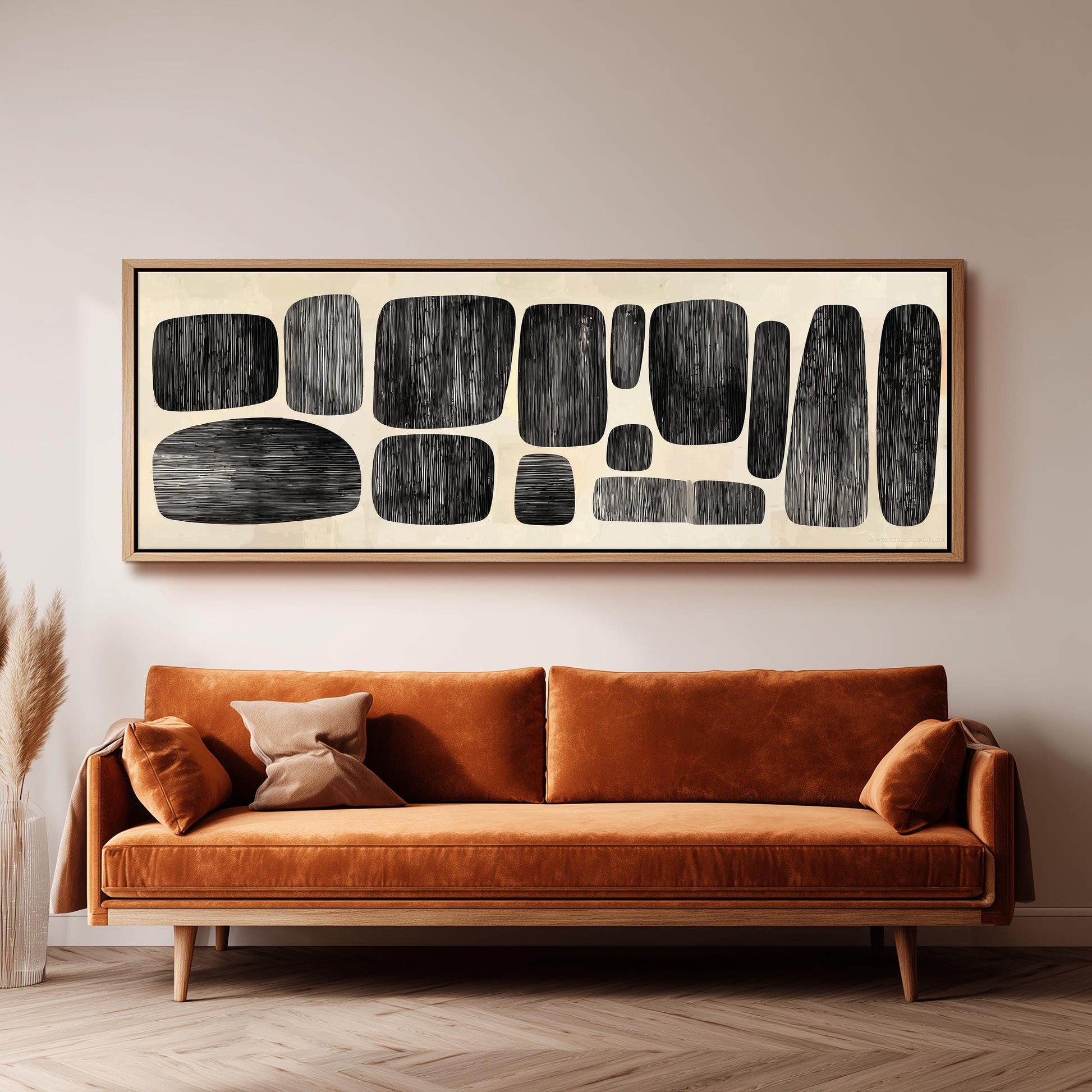 a large abstract painting hanging on a wall above a brown sofa with orange cushions.