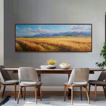 a dining room with a large painting of a field of golden wheat hanging on the wall above a wooden dining table with four chairs. The table is set with a bowl of fruit and a vase of flowers, creating a cozy and inviting atmosphere.