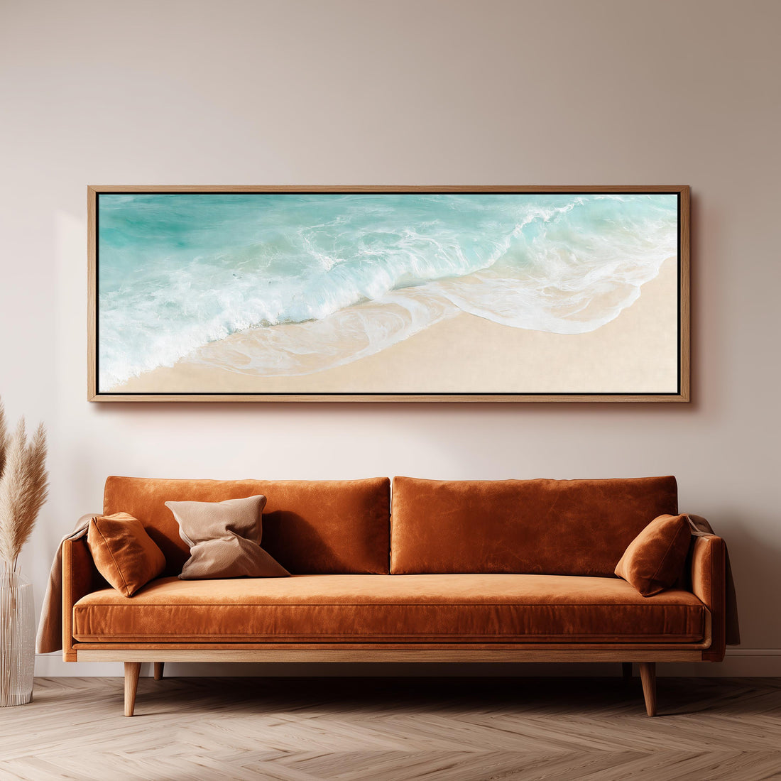 Turquoise wave washing onto sand from above long horizontal canvas print above a sofa in a living room