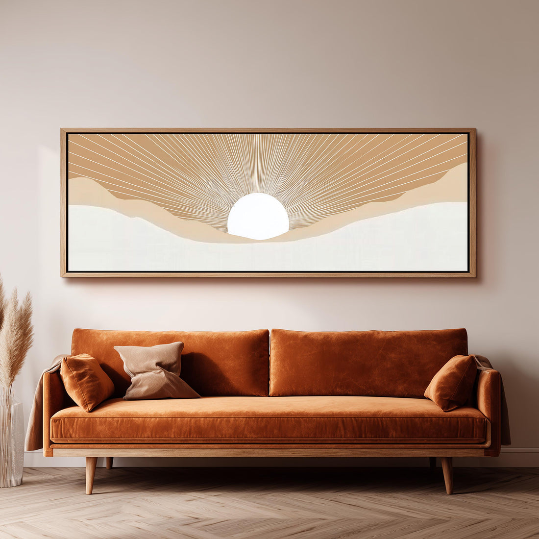 a large, rectangular, framed artwork depicting a sun-like design on a wall above a brown sofa with two pillows.