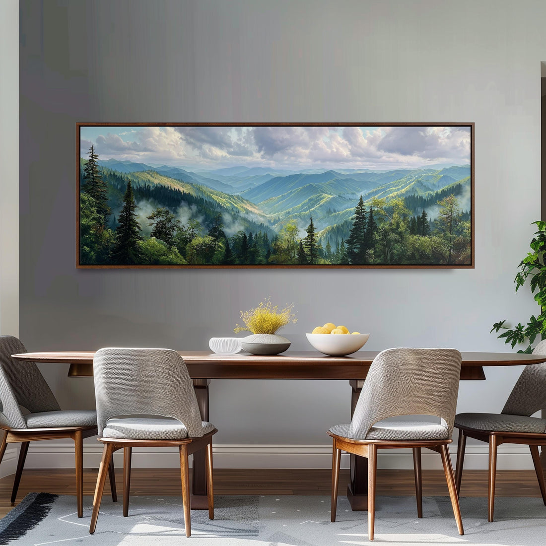 a large painting of a mountainous landscape hanging on a wall above a wooden dining table with four chairs.