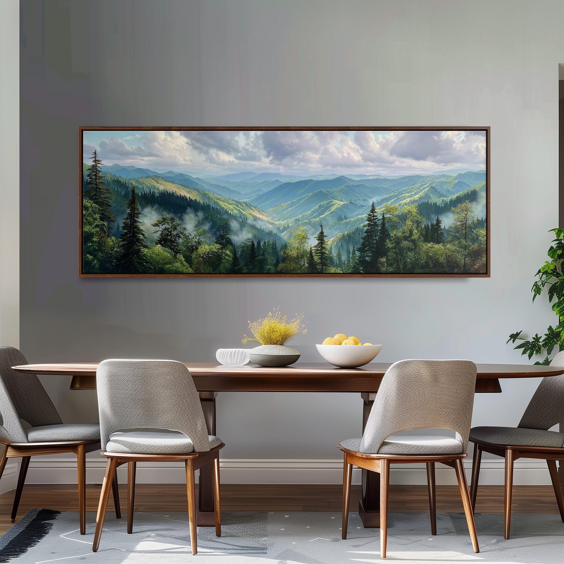 a large painting of a mountainous landscape hanging on a wall above a wooden dining table with four chairs.