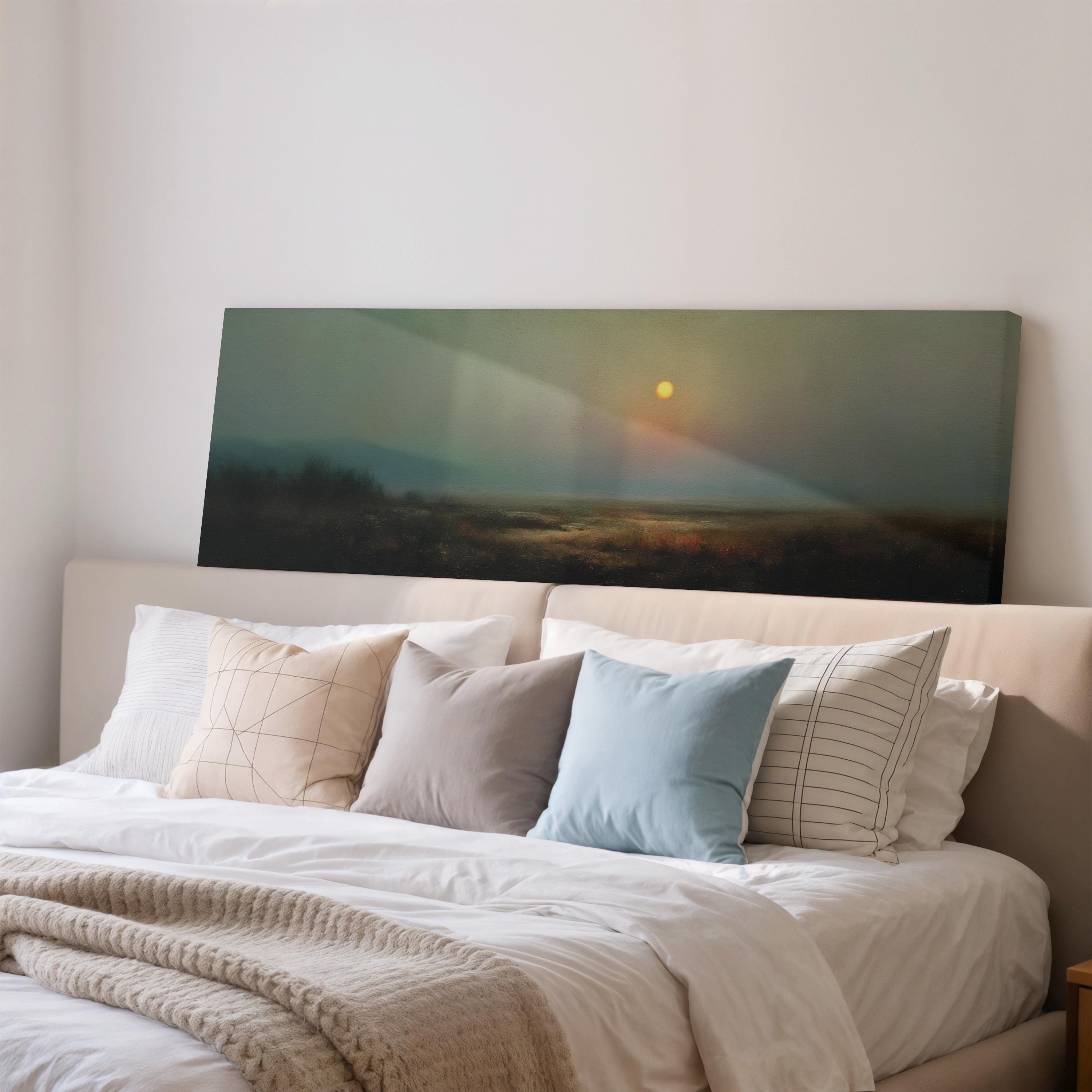 a serene bedroom scene with a large bed adorned with white linens and a variety of colorful pillows. Above the bed, a large canvas print of a landscape with a sunset is displayed, creating a peaceful and inviting atmosphere.