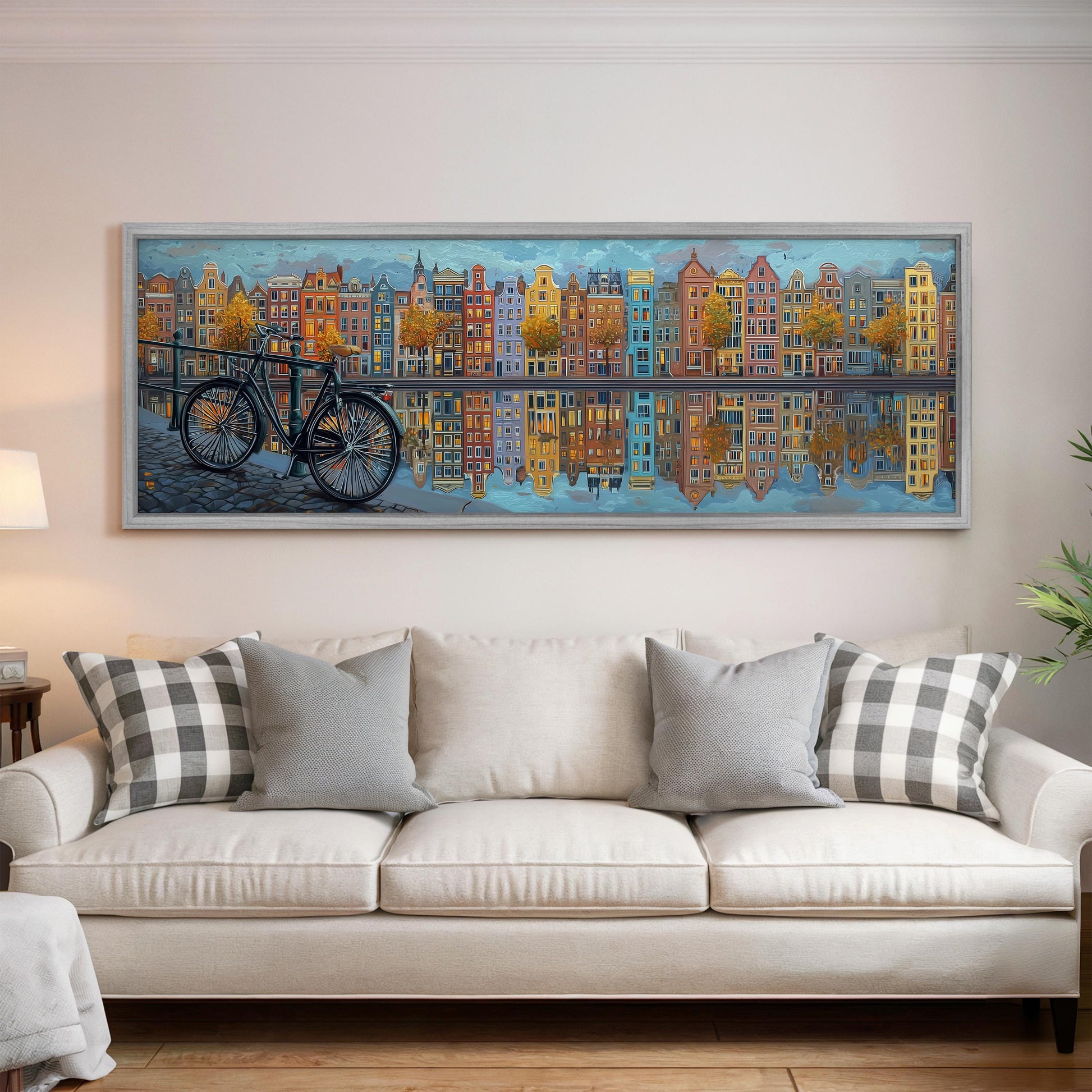 a large painting of a cityscape with a bicycle in the foreground, hanging on a wall above a white couch with patterned throw pillows.