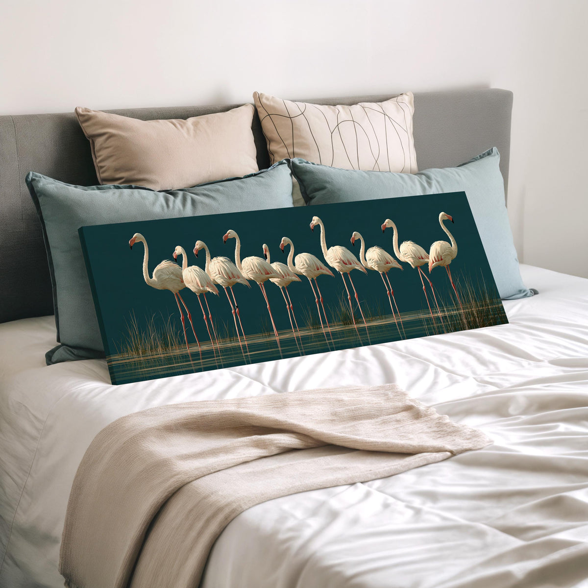Pale flamingos wading on teal wide panoramic canvas print laid on a bed to show its size