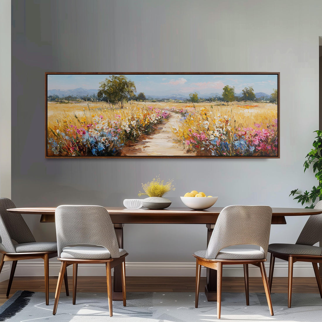 a large, framed painting of a field with flowers hanging on a wall above a brown sofa.