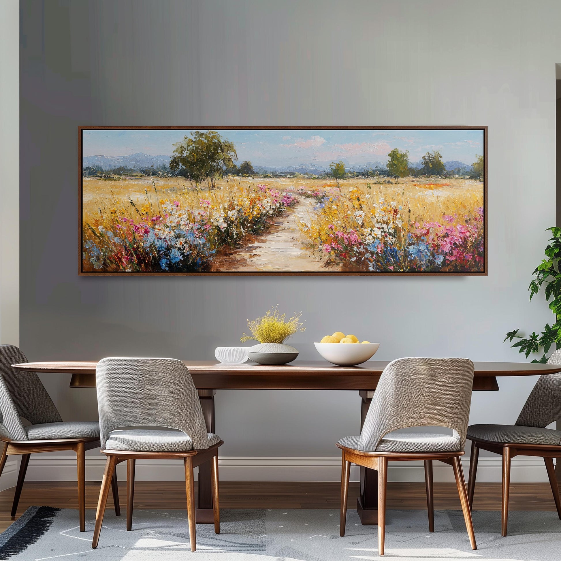 a large painting of a field with flowers hanging on the wall above a wooden dining table with four chairs.