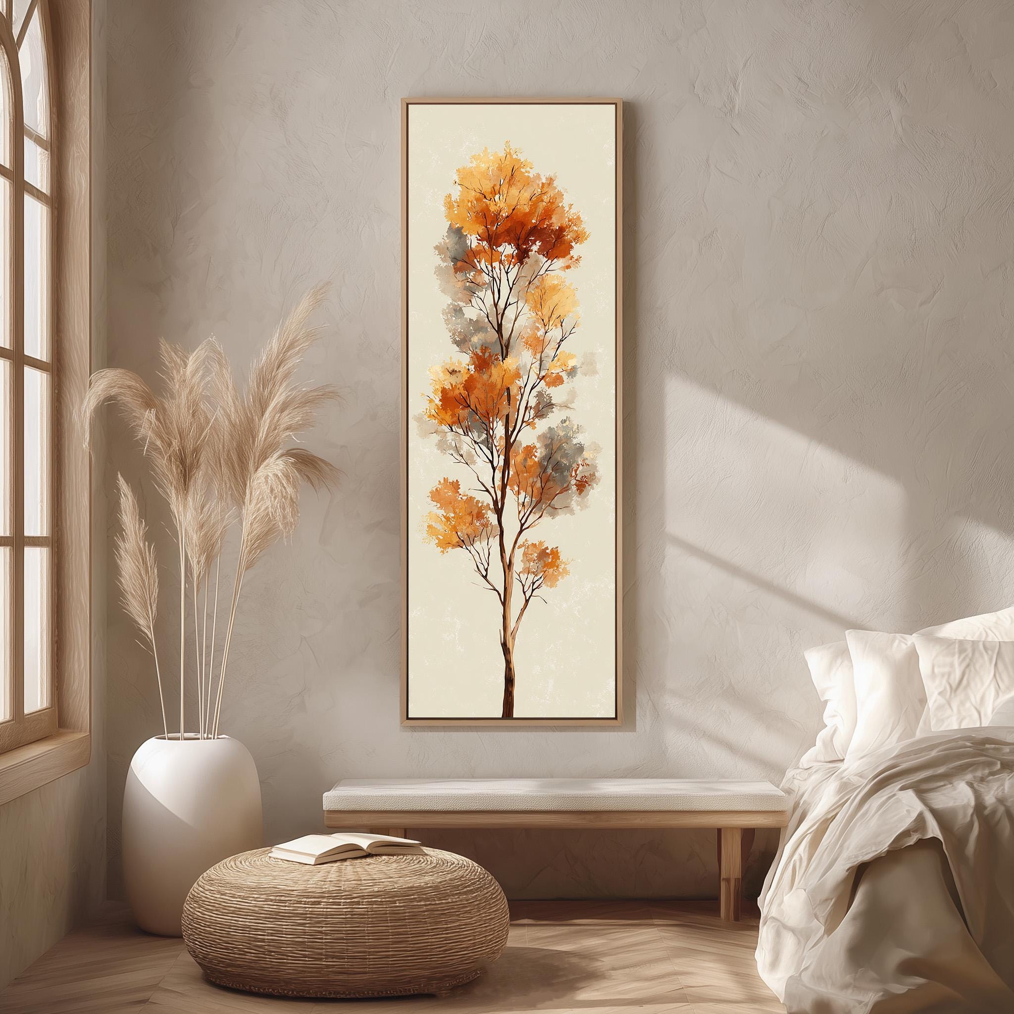 a serene and cozy bedroom scene, featuring a large painting of a tree with vibrant orange leaves hanging on the wall, a white bed with a white pillow and blanket, a white vase with tall potted plants, and a woven ottoman in front of the bed.