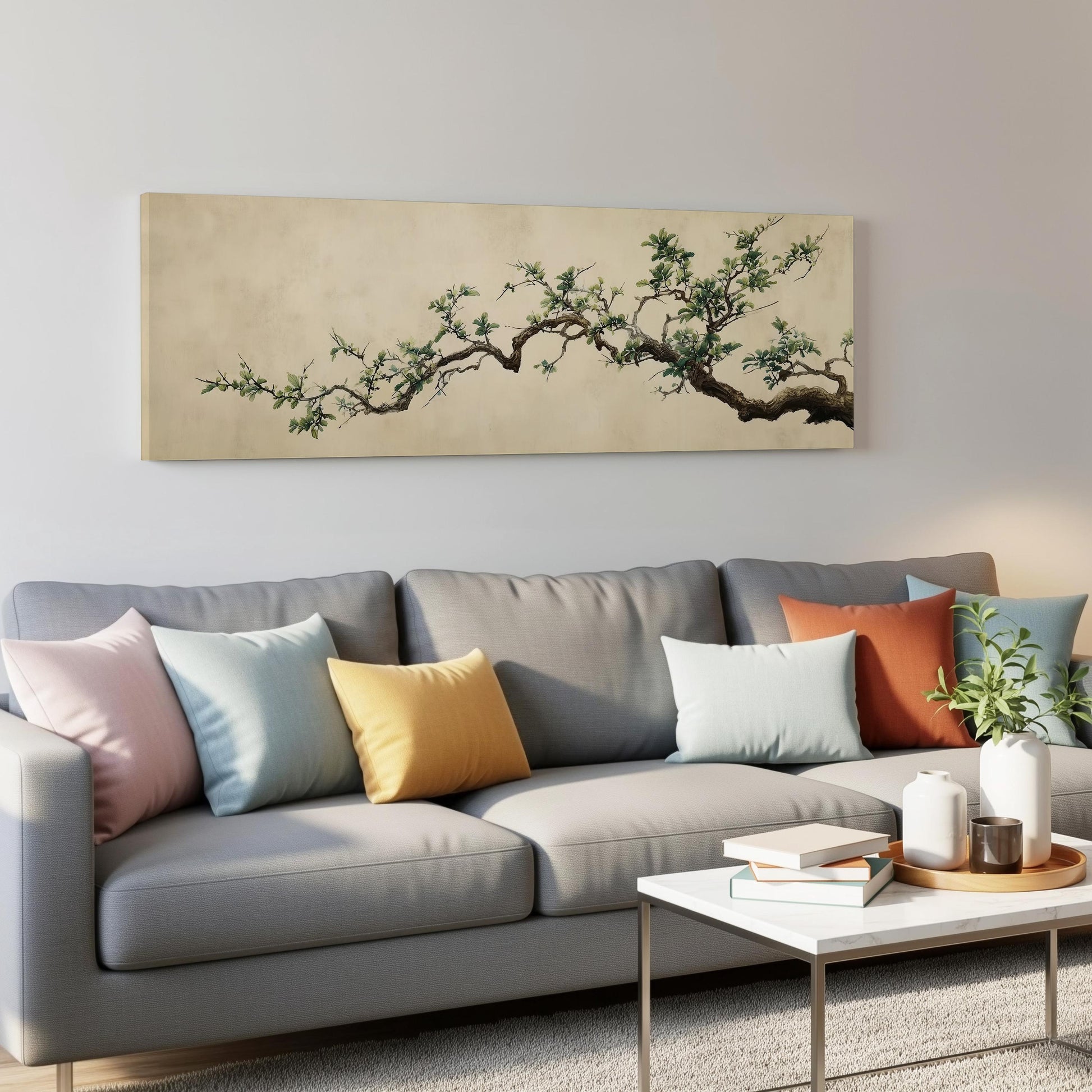 a gray couch with colorful throw pillows, a coffee table, and a large painting of a tree branch hanging on the wall above the couch.