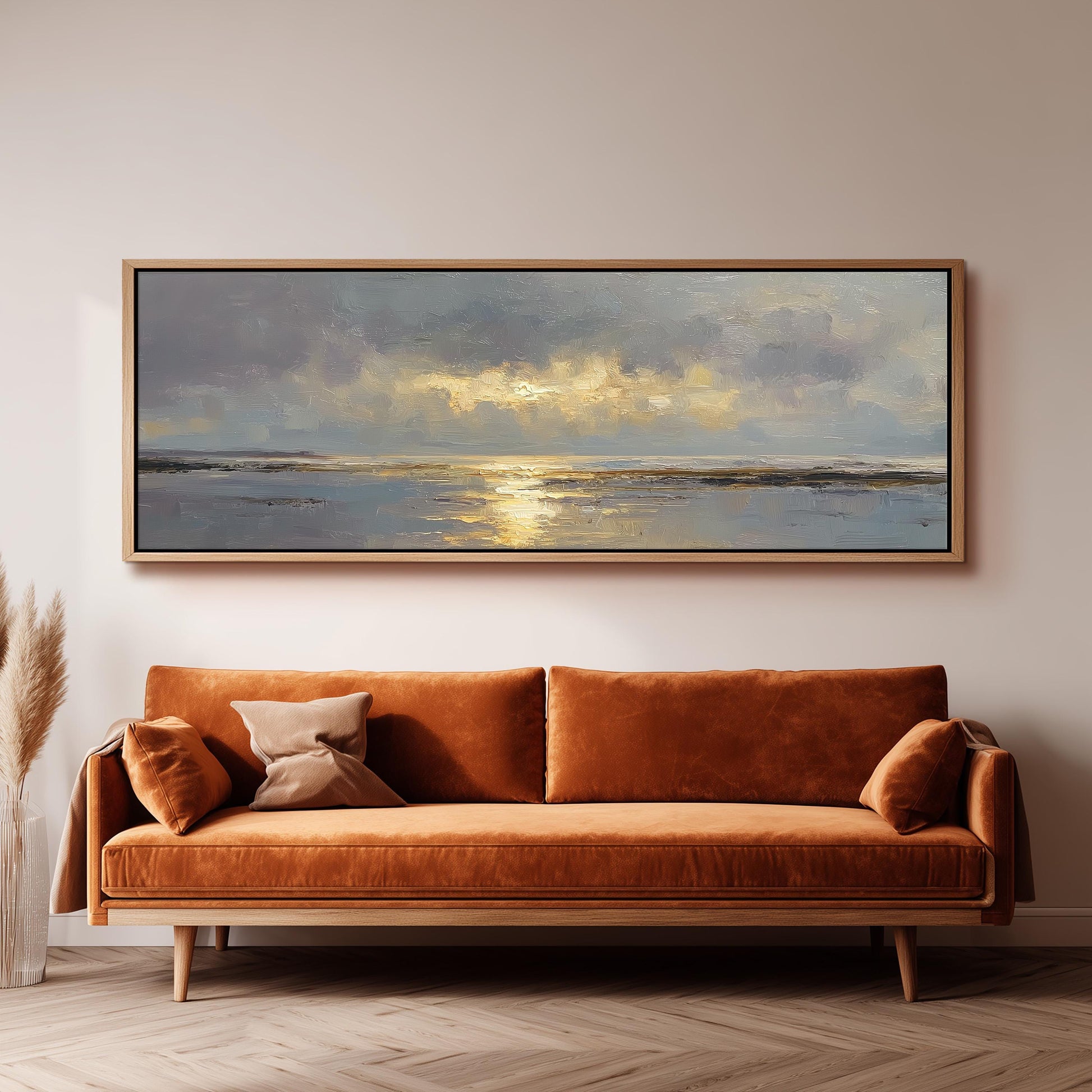 a large, rectangular painting hanging on a wall above a brown sofa with orange cushions.