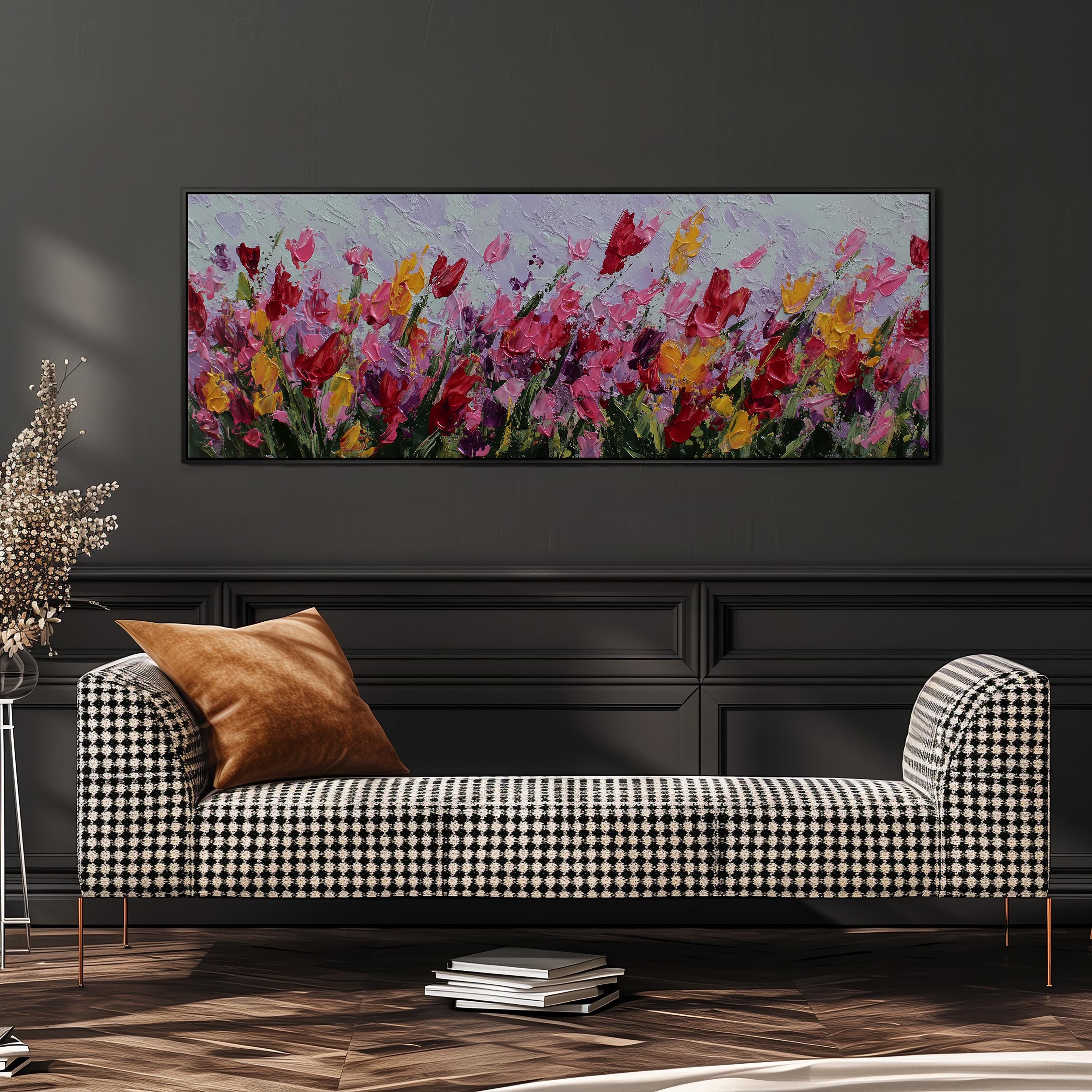 a large, colorful painting of flowers hanging on a wall above a black and white checkered sofa in a living room setting.