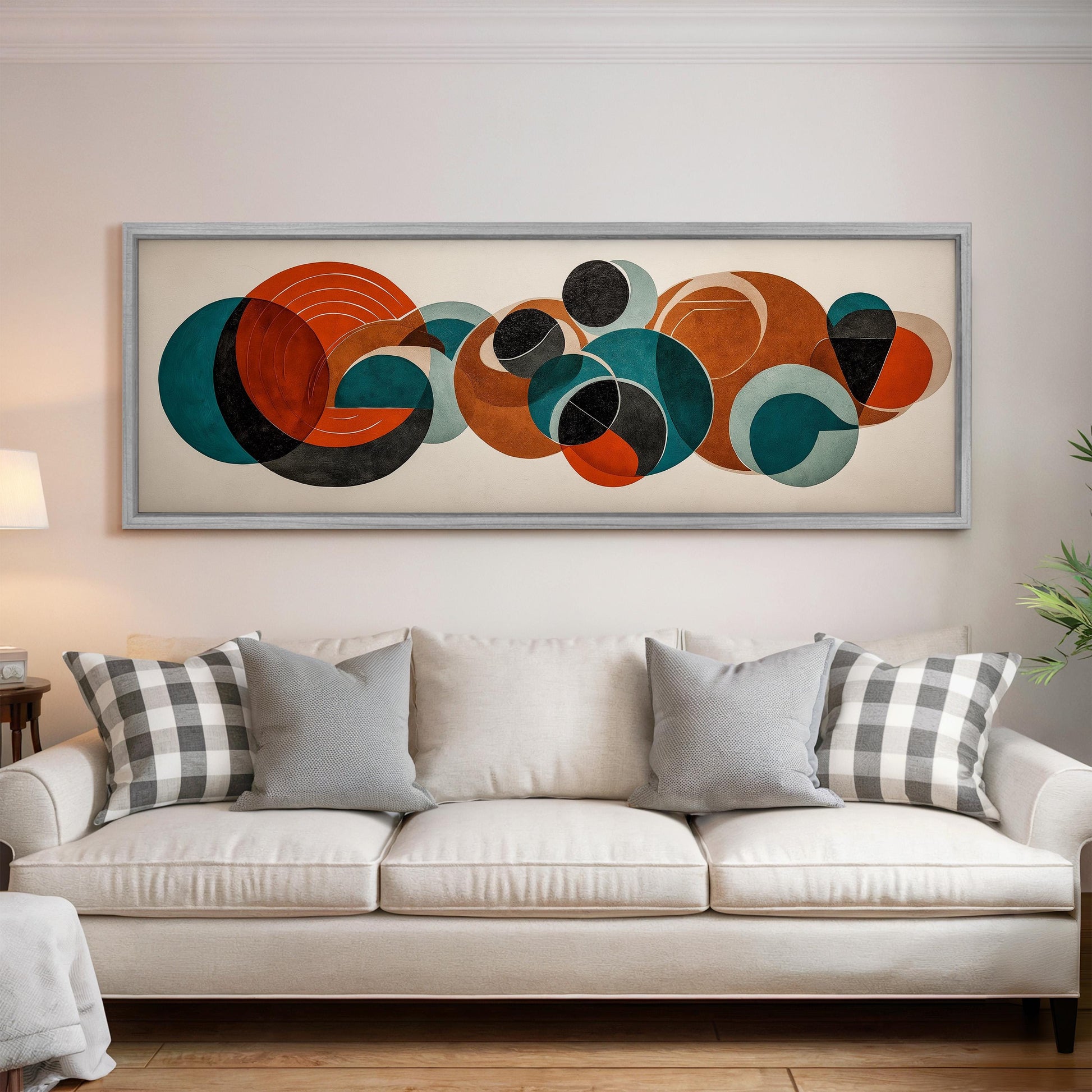 a large abstract painting hanging on a wall above a white couch with gray and white plaid throw pillows.