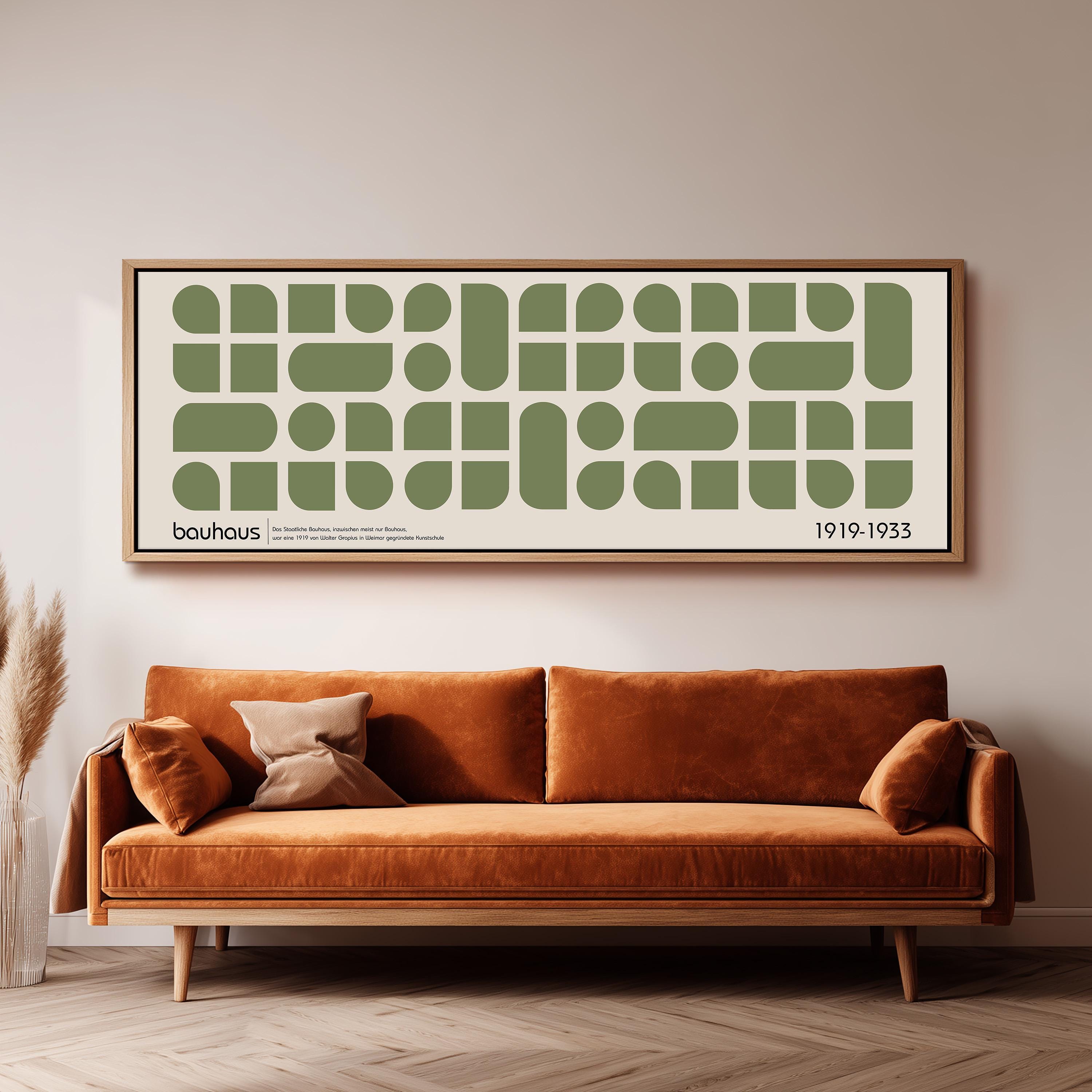 a large framed poster of a repeating geometric pattern in shades of green and white, hanging on a wall above a brown sofa with a wooden frame.