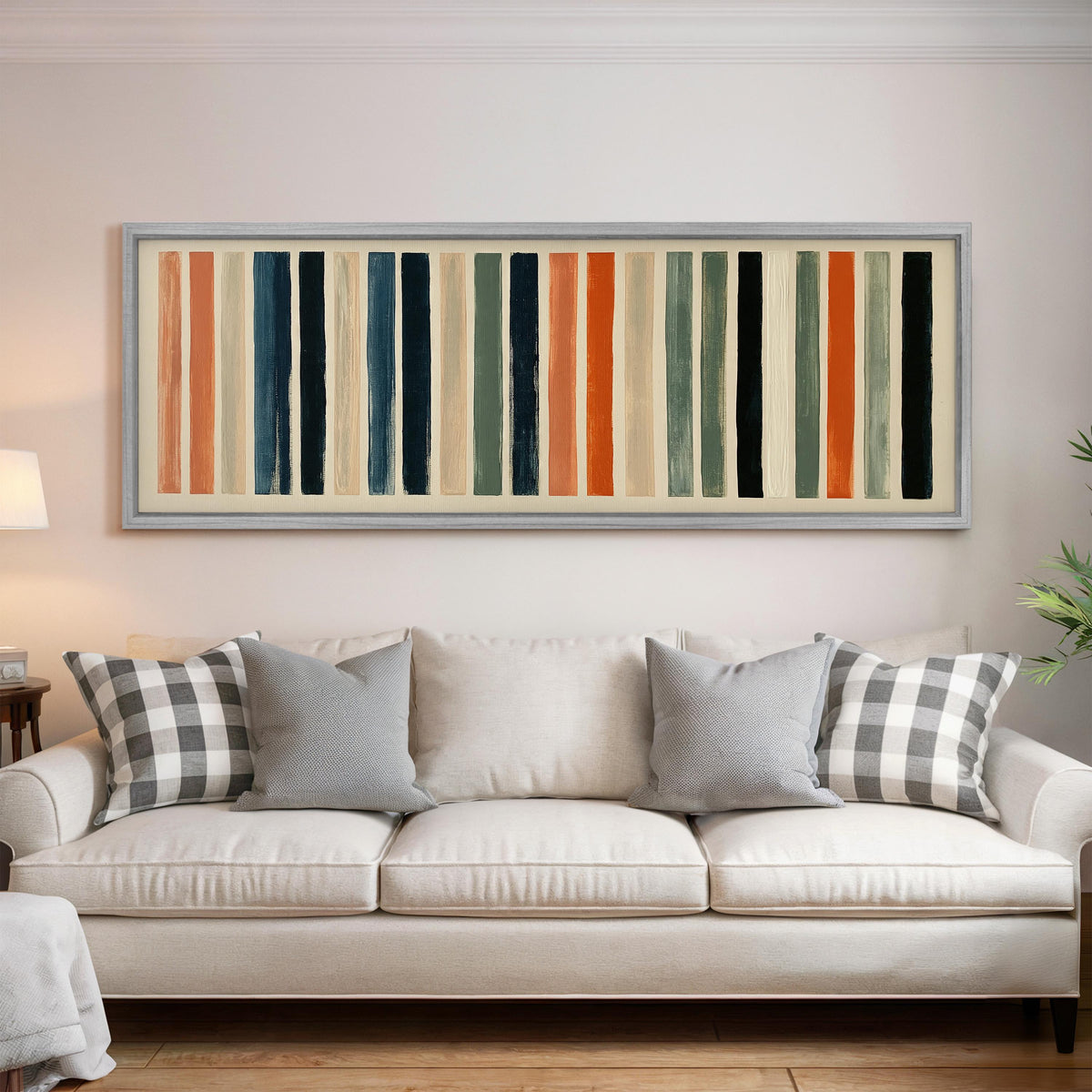 Bold peach, sage and navy stripes panoramic canvas print above a white sofa in a bright living room