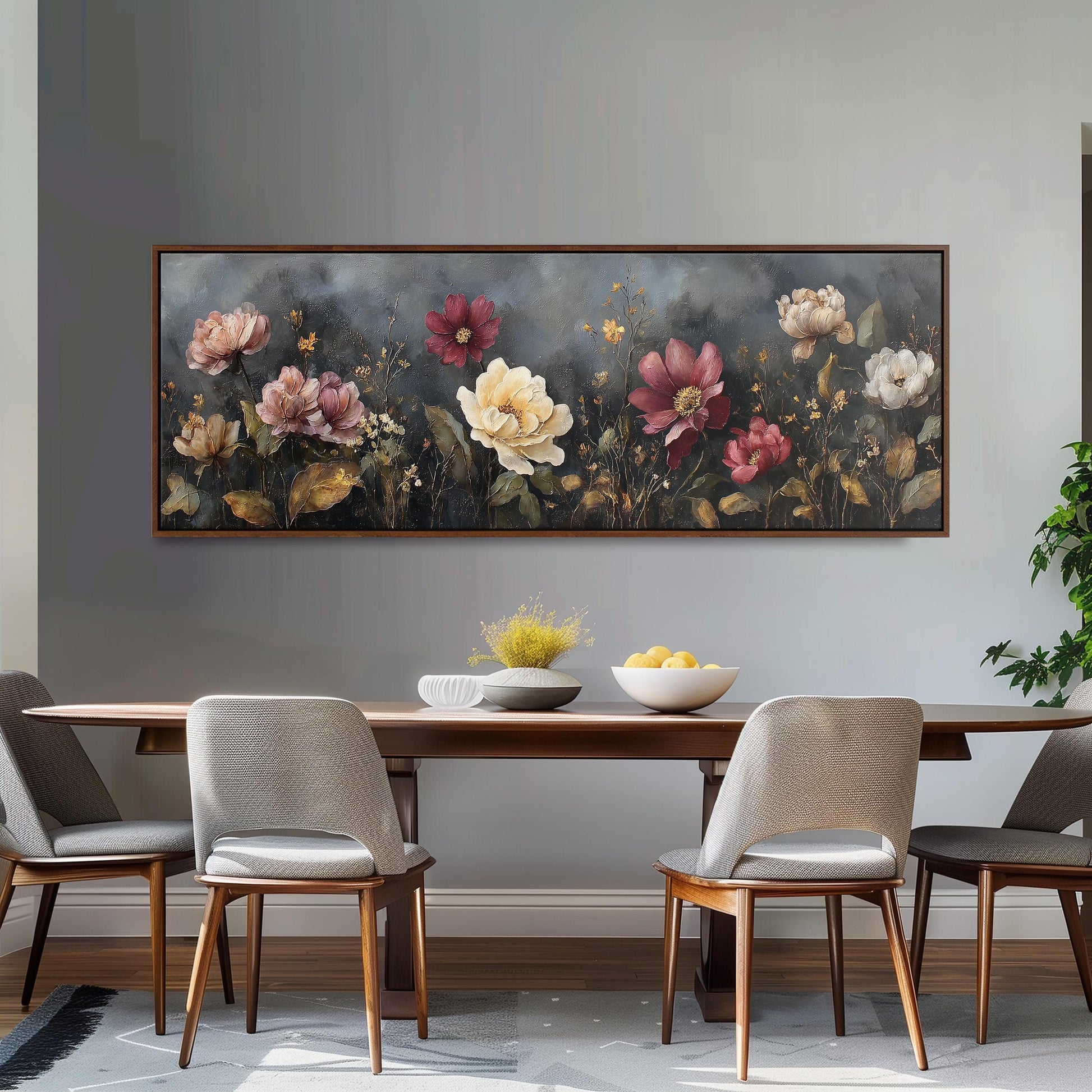 a dining room with a large floral painting hanging on the wall above a wooden dining table. The table is set with a bowl of fruit and a vase of flowers, creating a cozy and inviting atmosphere.