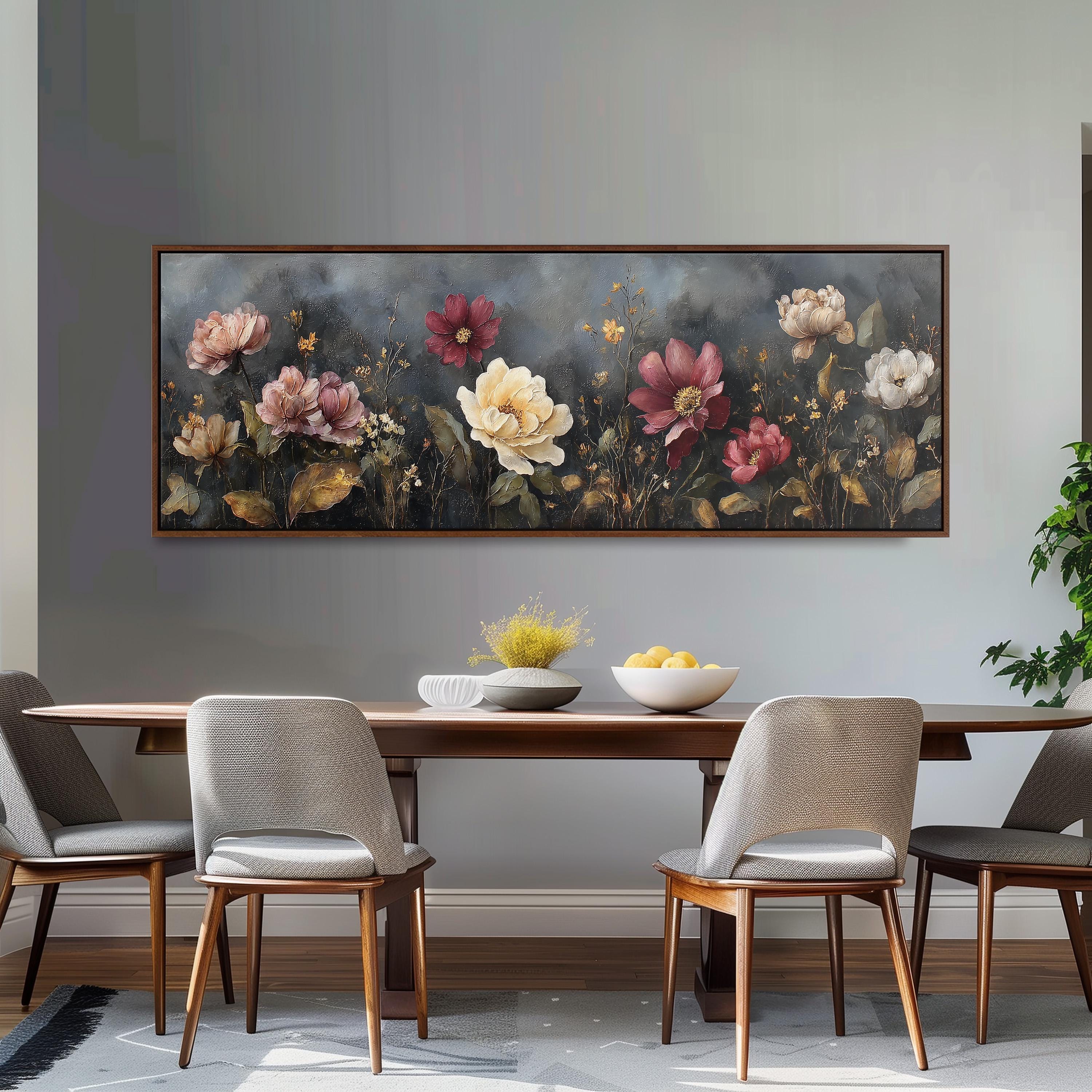 a dining room with a large floral painting hanging on the wall above a wooden dining table. The table is set with a bowl of fruit and a vase of flowers, creating a cozy and inviting atmosphere.
