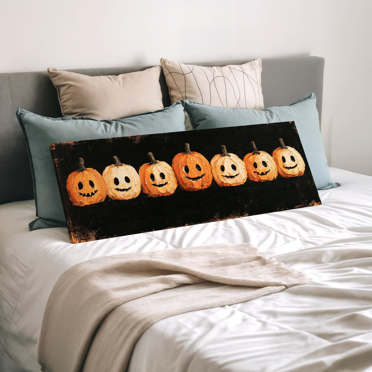 Row of smiling jack-o'-lanterns wide panoramic canvas print laid on a bed to show its size