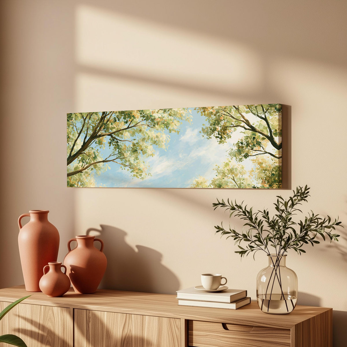 Sunlit leafy branches framing soft clouds long horizontal canvas print above a wooden sideboard