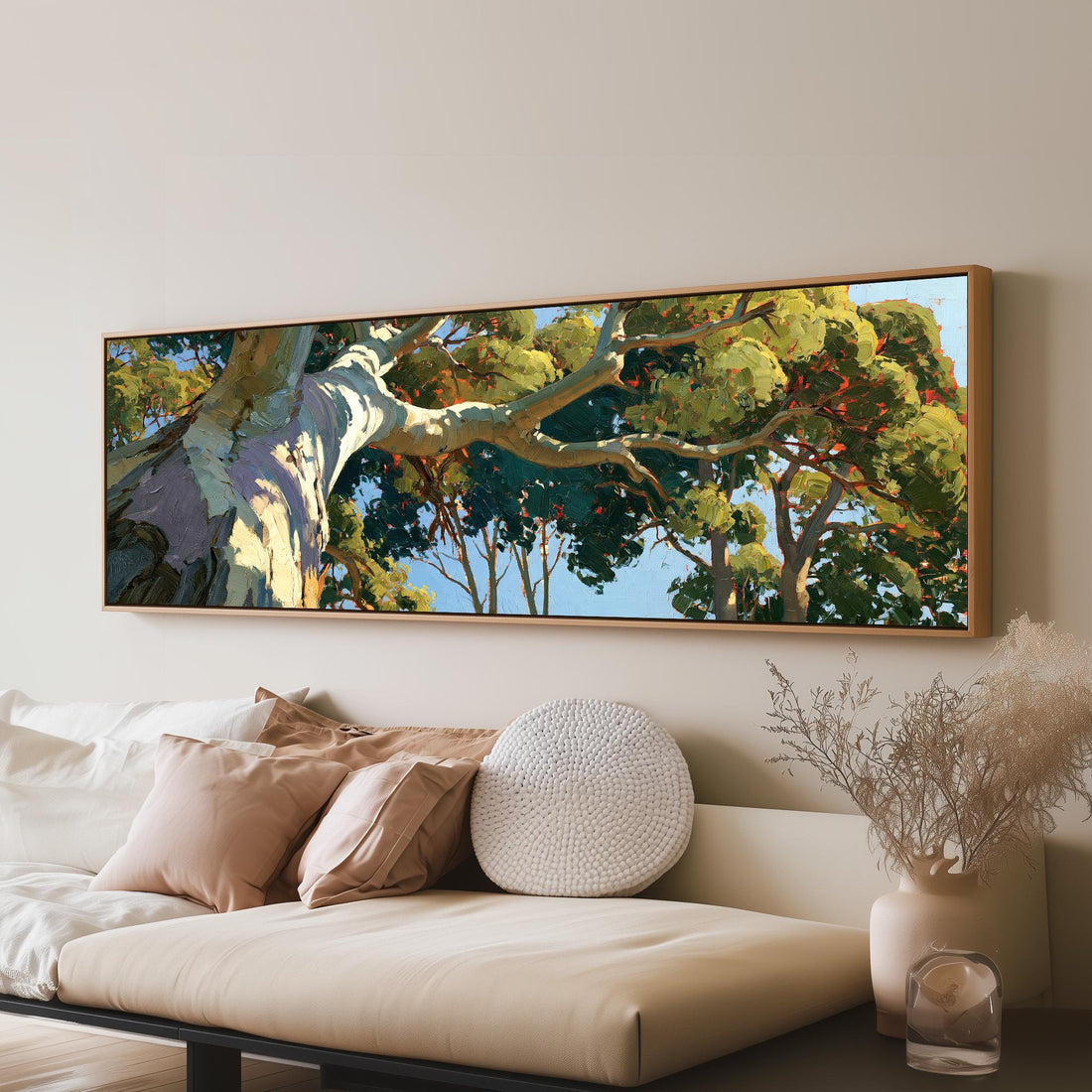 Sunlit eucalyptus trunk and branches long horizontal canvas print above a sofa in a living room