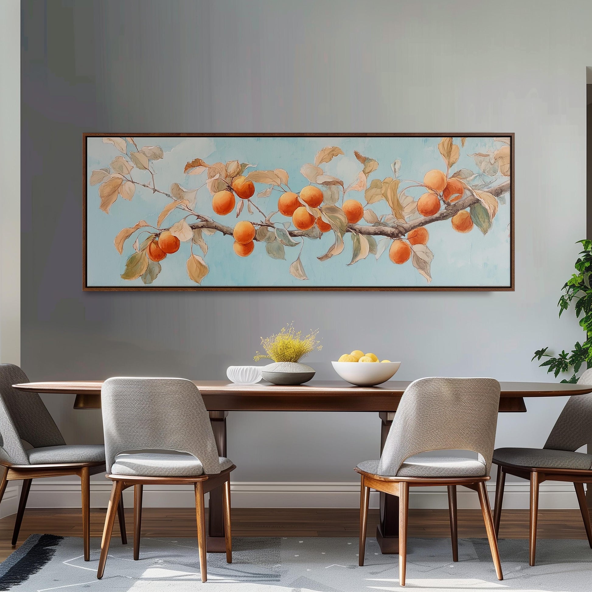 a dining room with a large painting of a tree branch with oranges hanging from it, a wooden table with a bowl of fruit, and four chairs around the table.