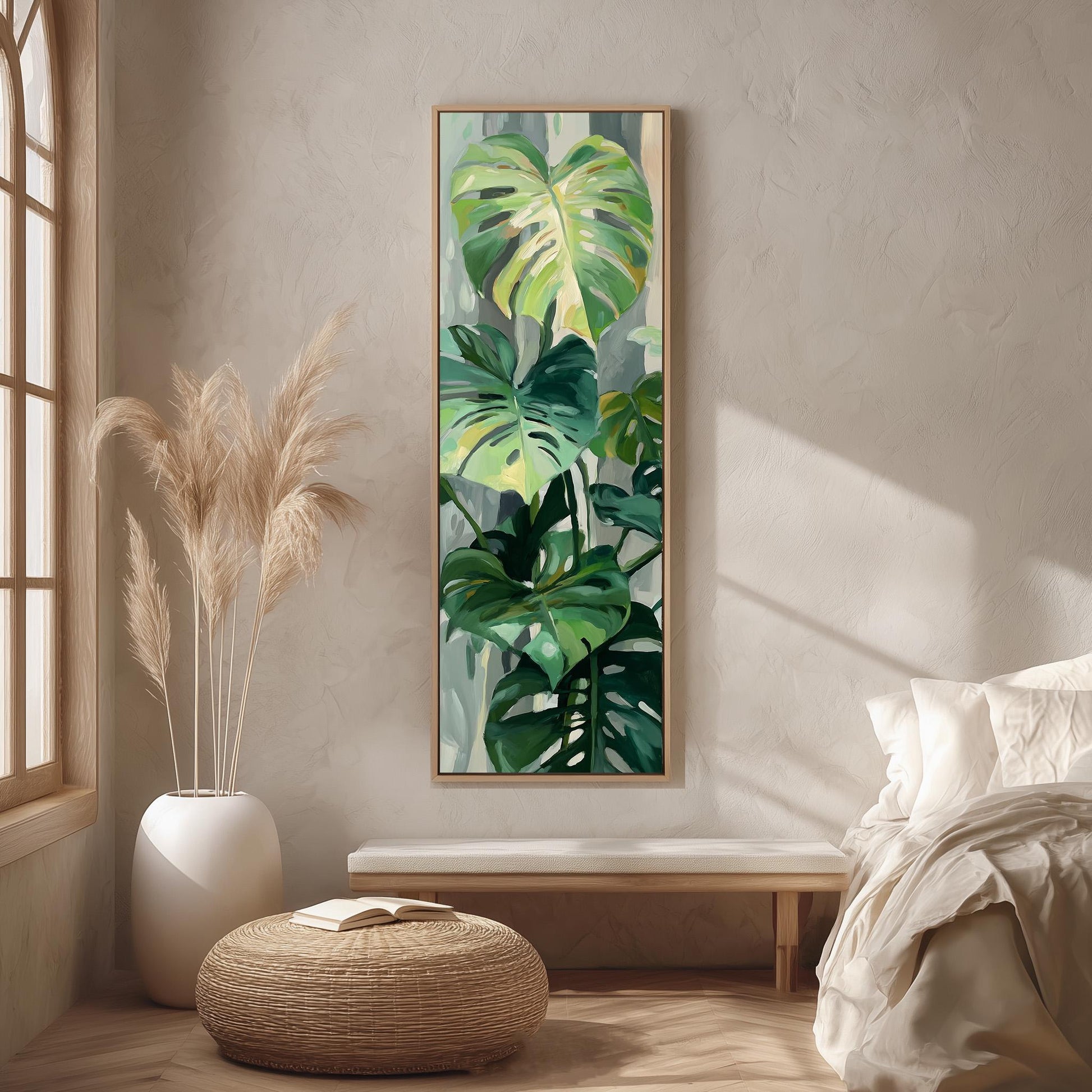 a large painting of tropical plants hanging on a wall in a room with a bed, a wicker ottoman, and a window.