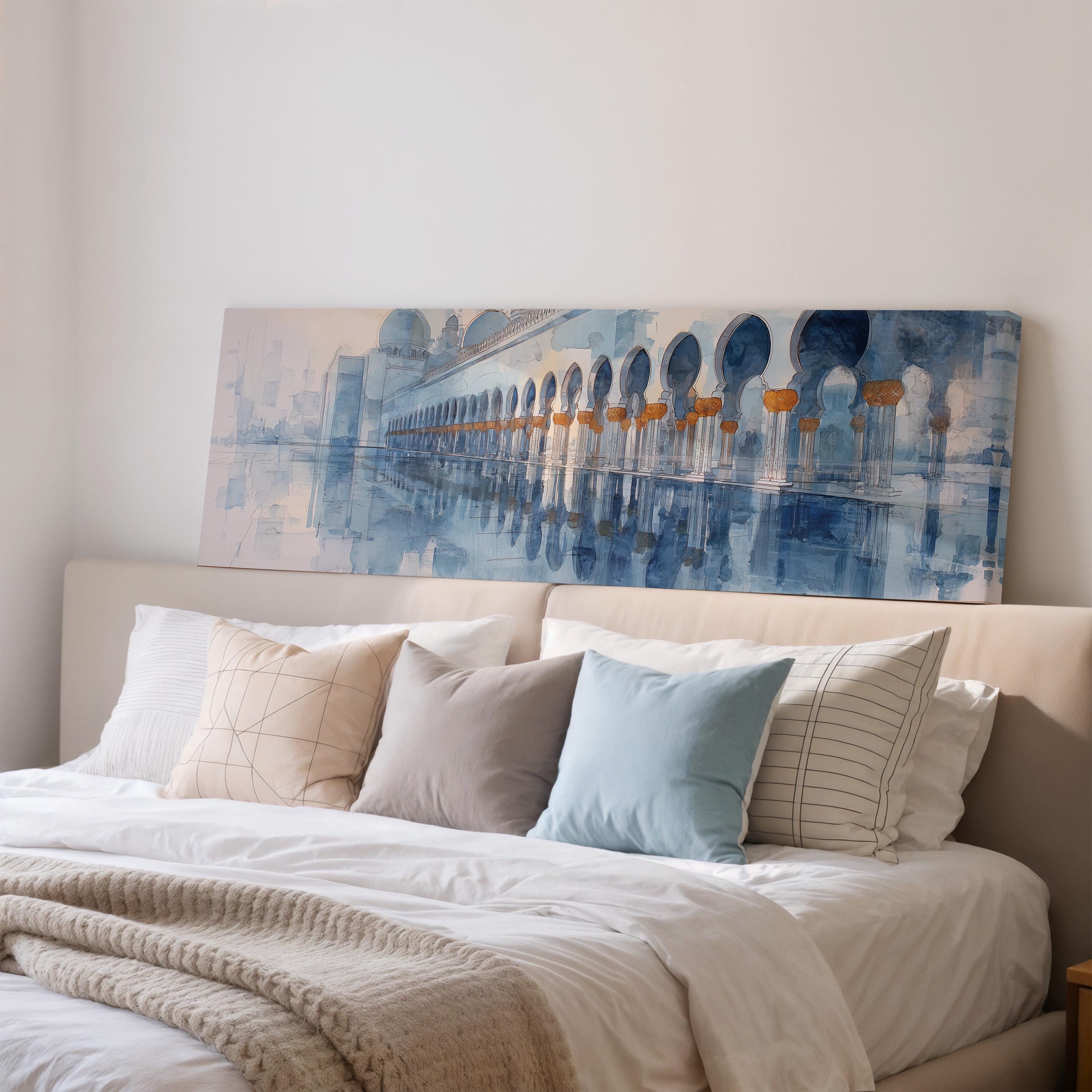 a large painting of a building with arches hanging above a bed with white bedding and pillows.