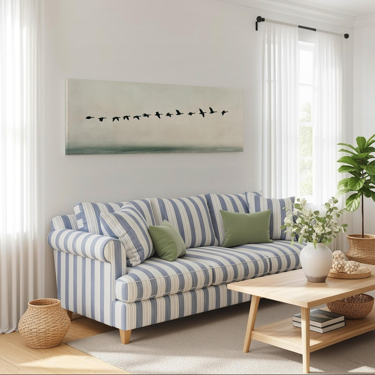 Geese flying over still water long horizontal canvas print above a striped sofa in a coastal living room